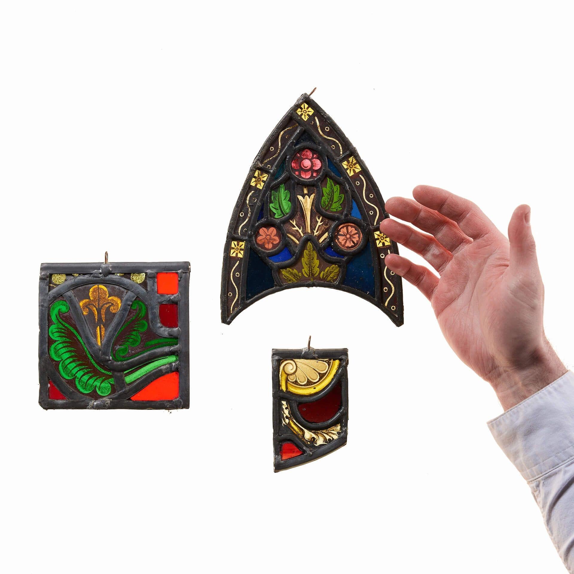 A group of 3 small decorative stained glass window hanging panels, all reclaimed from fragments of 19th century religious stained glass windows. This interesting trio are perfect for hanging in a window or in front of a light source where their