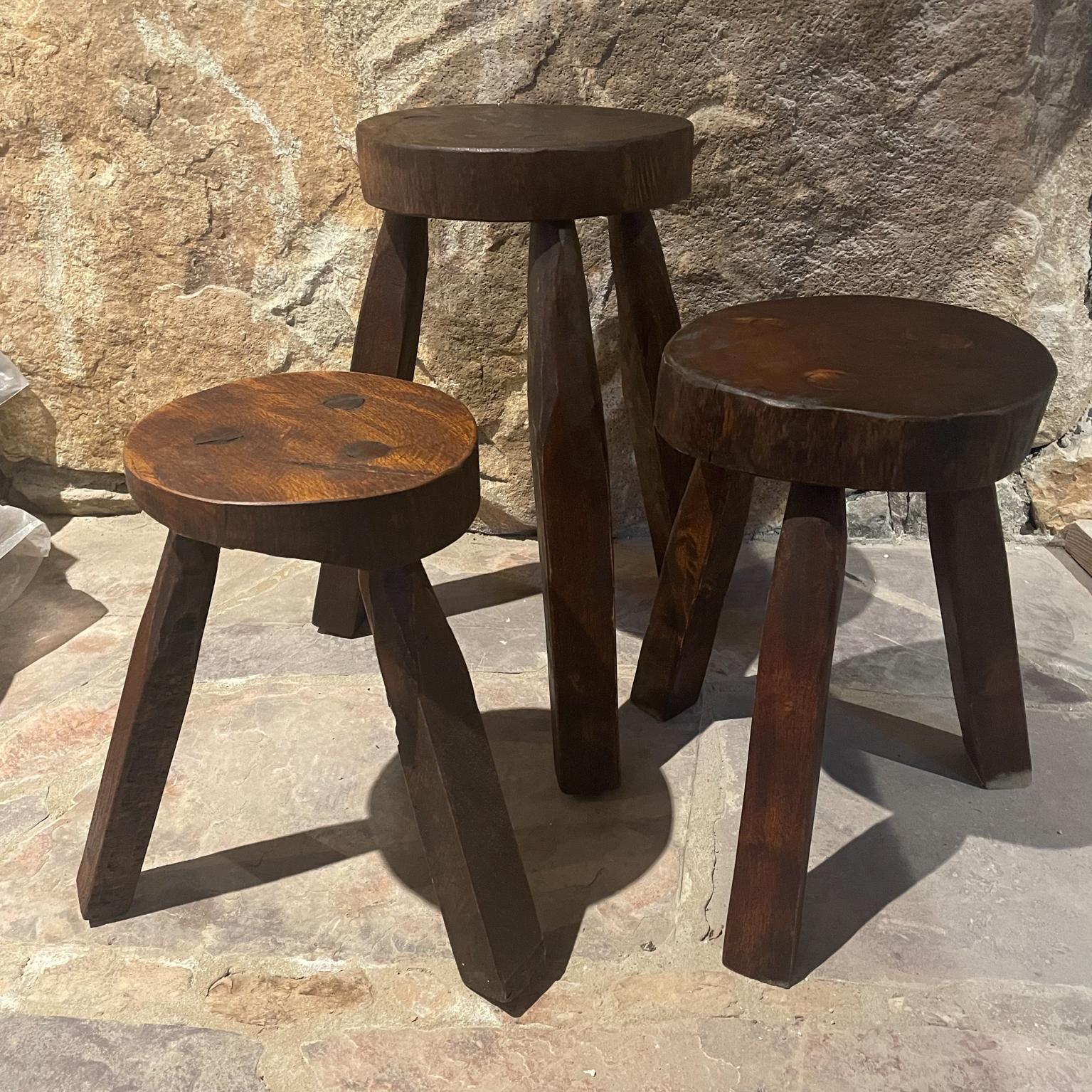 Vintage Set of 3 Rustic Milking Stools
Carved Solid Wood Three-Legged tripod in the style of Pierre Jeanneret
Unmarked. 
Three different sizes.
1) 18.5 H x 16 D 10 D top 2) 14.38 H 14 D x 9.5 D top 3) 13.63 H 13 D 8 D top
Original vintage preowned