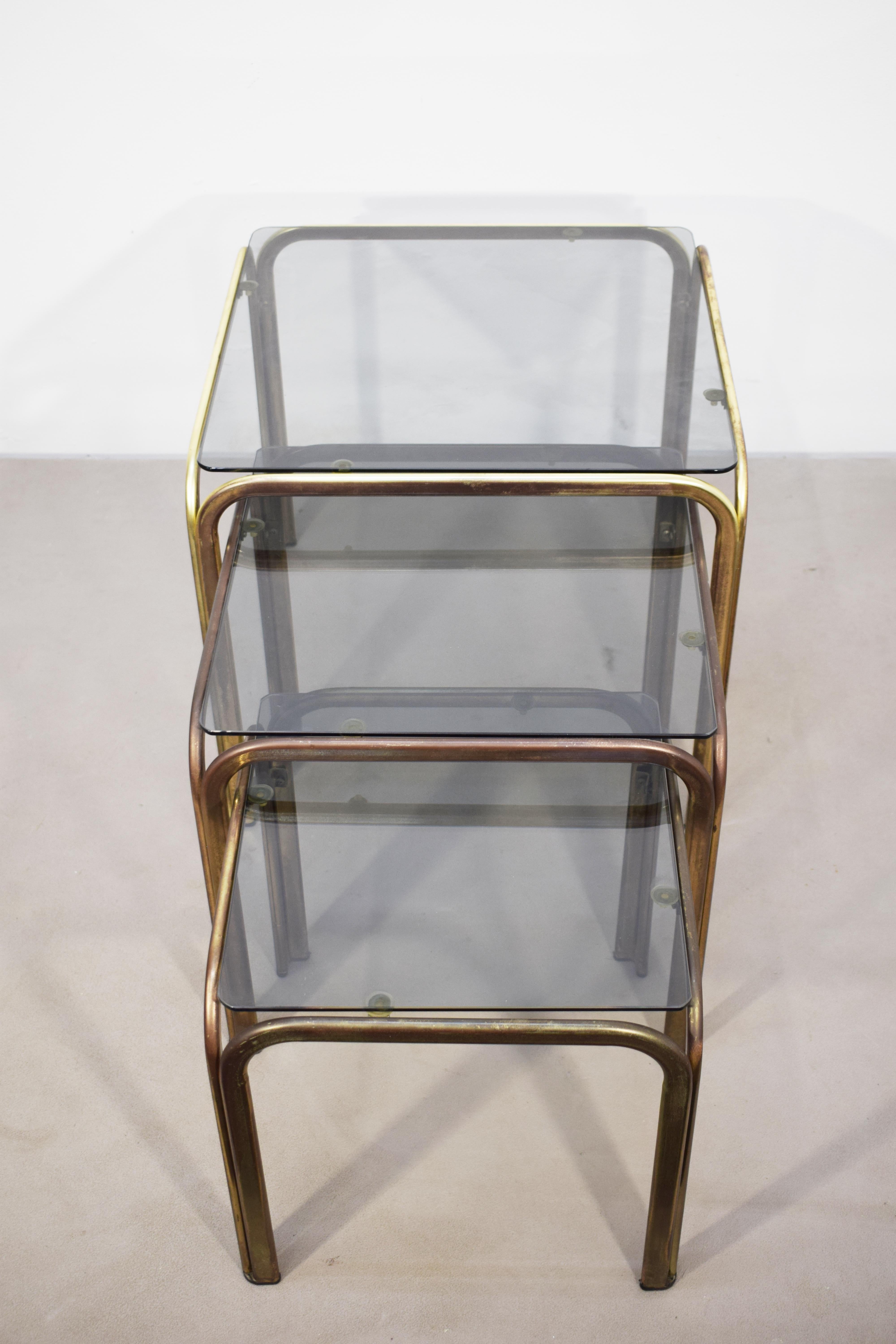 Italian Set of 3 stackable coffee tables, brass and smoked glass, 1970s. For Sale