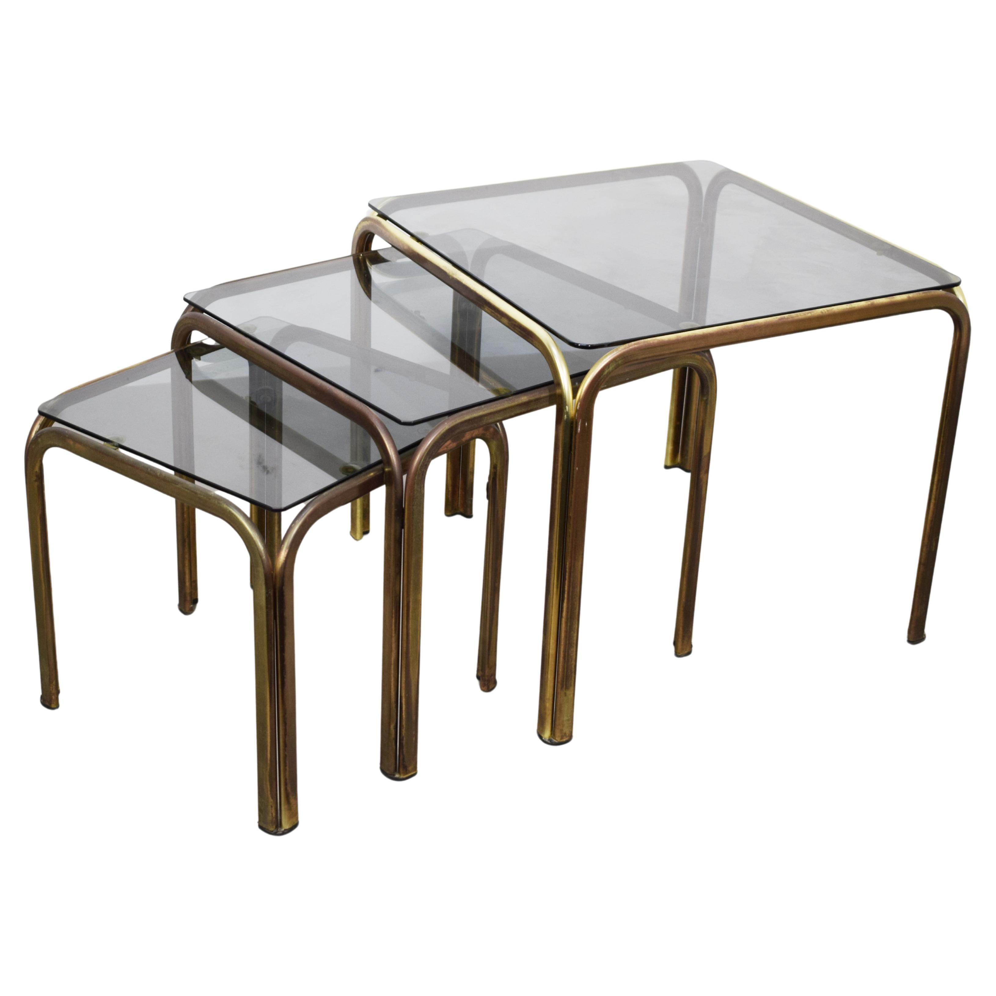 Set of 3 stackable coffee tables, brass and smoked glass, 1970s. For Sale