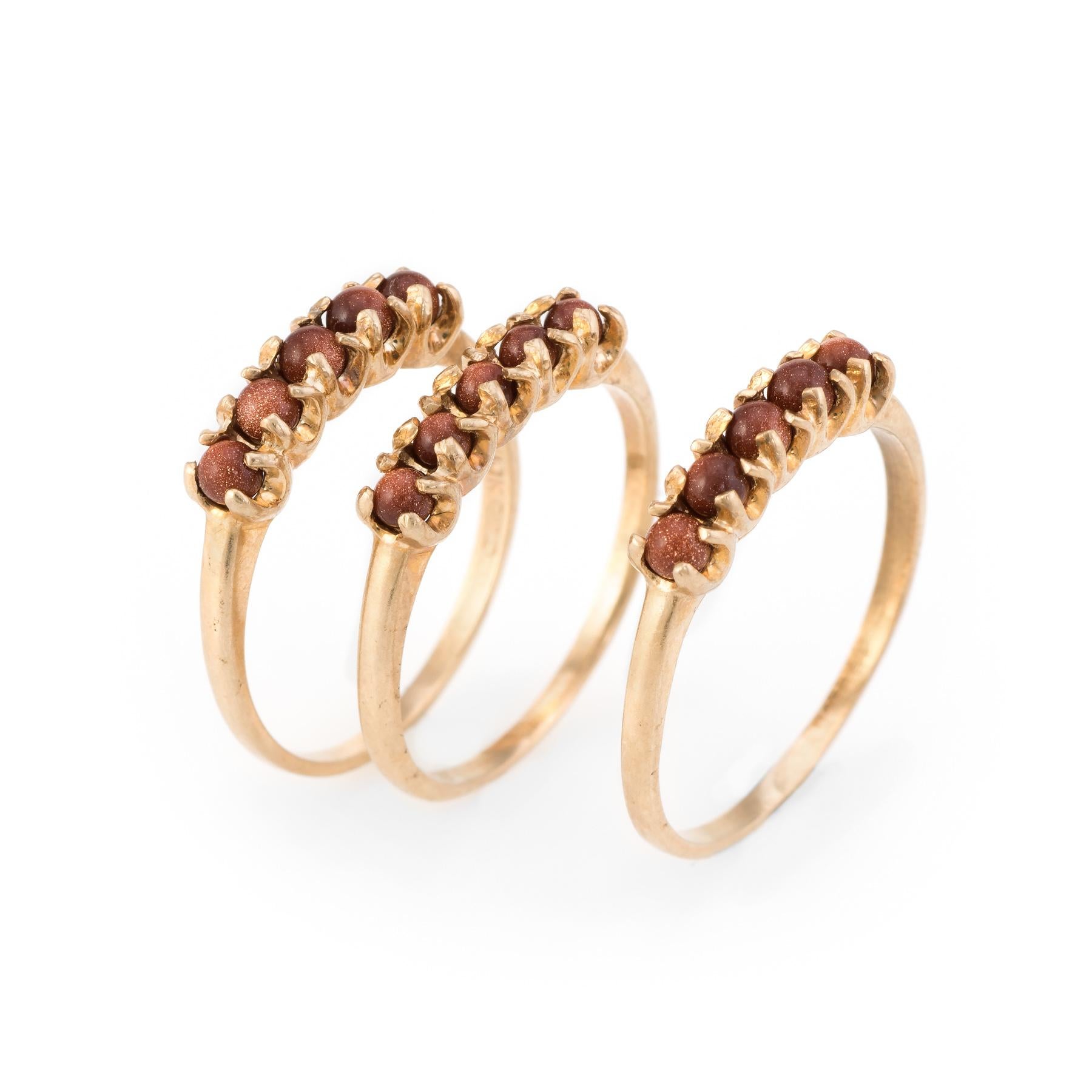 Finely detailed vintage set of 3 stacking rings, crafted in 10 karat yellow gold. 

Cabochon cut goldstone measures 2mm each (5 piece set into each of the bands). The stone is in excellent condition and free of cracks or chips. The goldstone