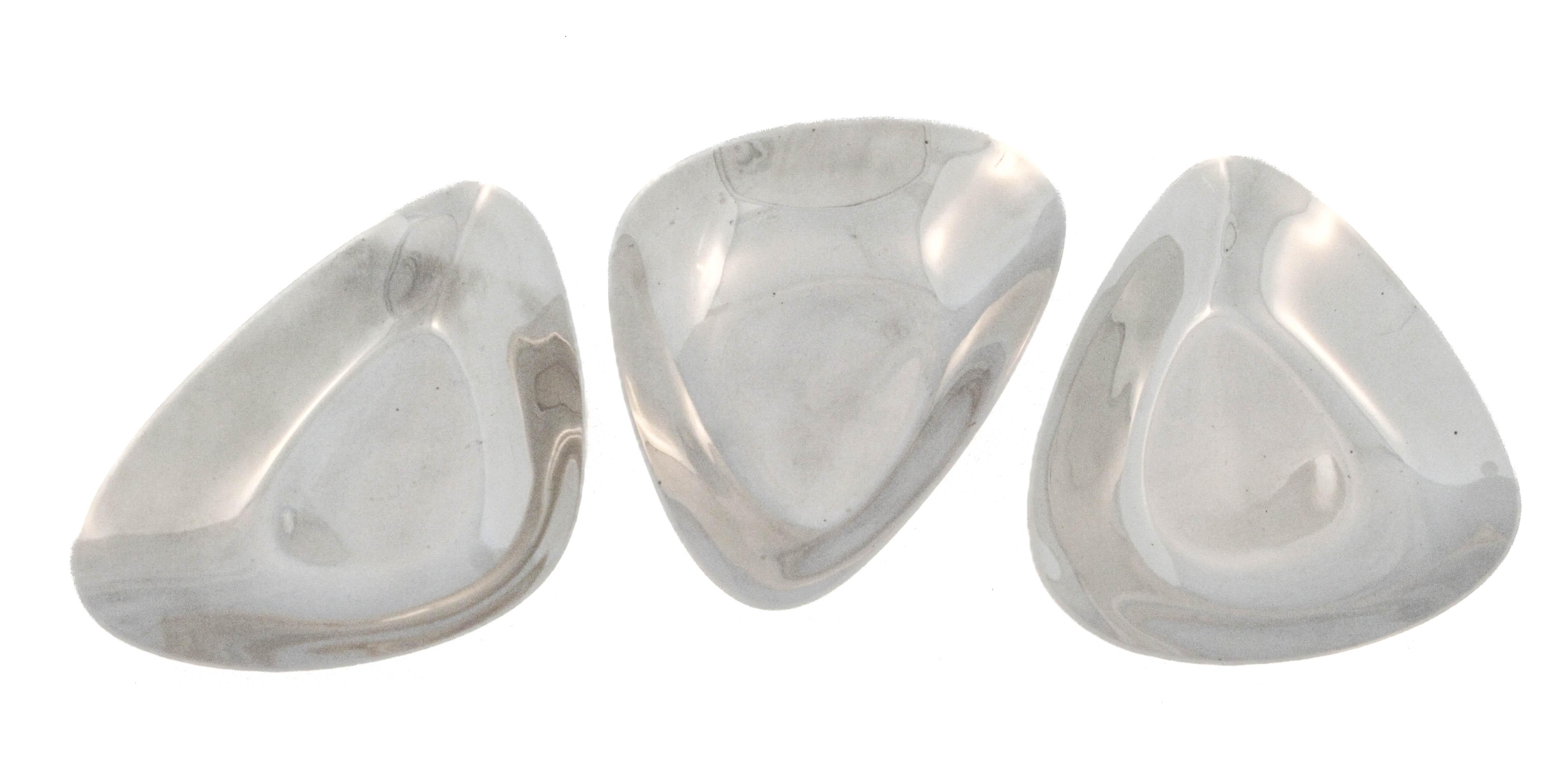 Questo sorprendente set di tre piatti per caramelle in argento sterling di Reed & Barton esemplifica l'estetica pulita e minimalista del design del Mid-Century Modern. Prodotti nel 1953 e contrassegnati da un apposito marchio, i piatti hanno una