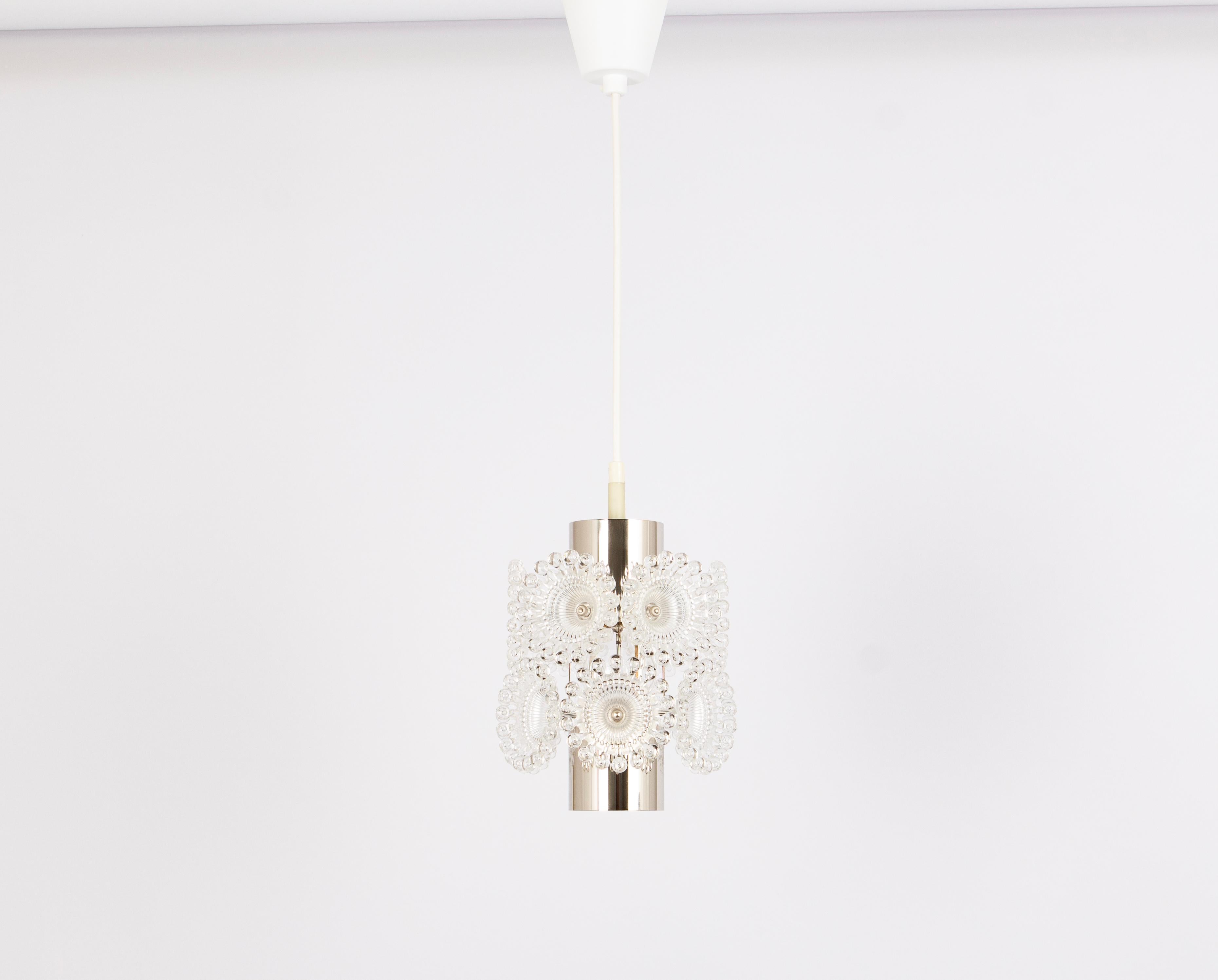 Set of 2 stunning petite floral plexiglass and chrome Sputnik Pendant lights, Germany, 1960s.
When illuminated, the pendant light transforms into a captivating work of art. The interplay of light and shadow created by its unique design elements