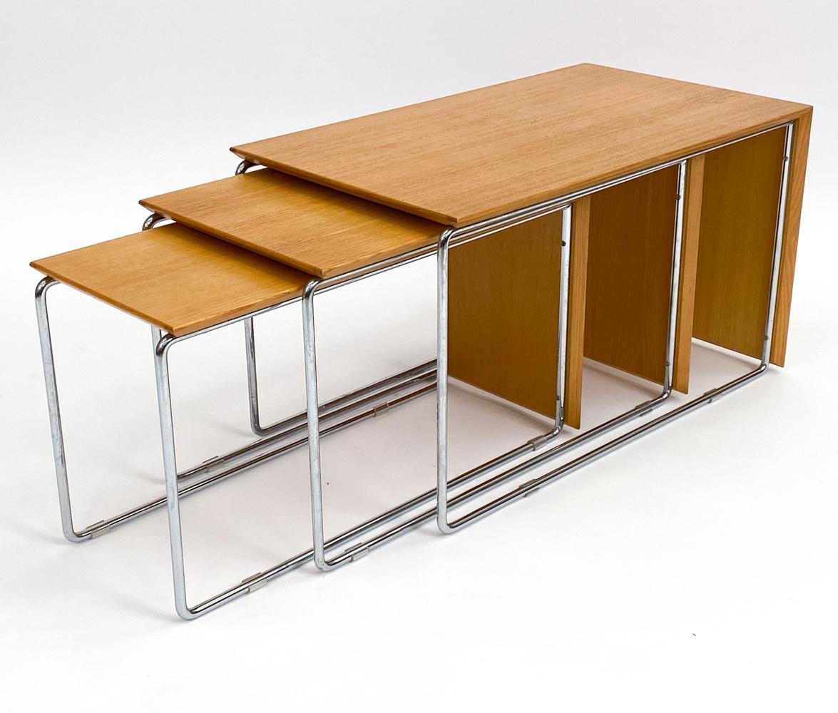 Tauchen Sie ein in das Herz des schwedischen Mid-Century-Designs mit diesem atemberaubenden Set aus drei von Marcel Breuer inspirierten Nisttischen. Diese Tische sind ein Beispiel für die perfekte Verbindung von natürlichem Eichenholz und glänzendem