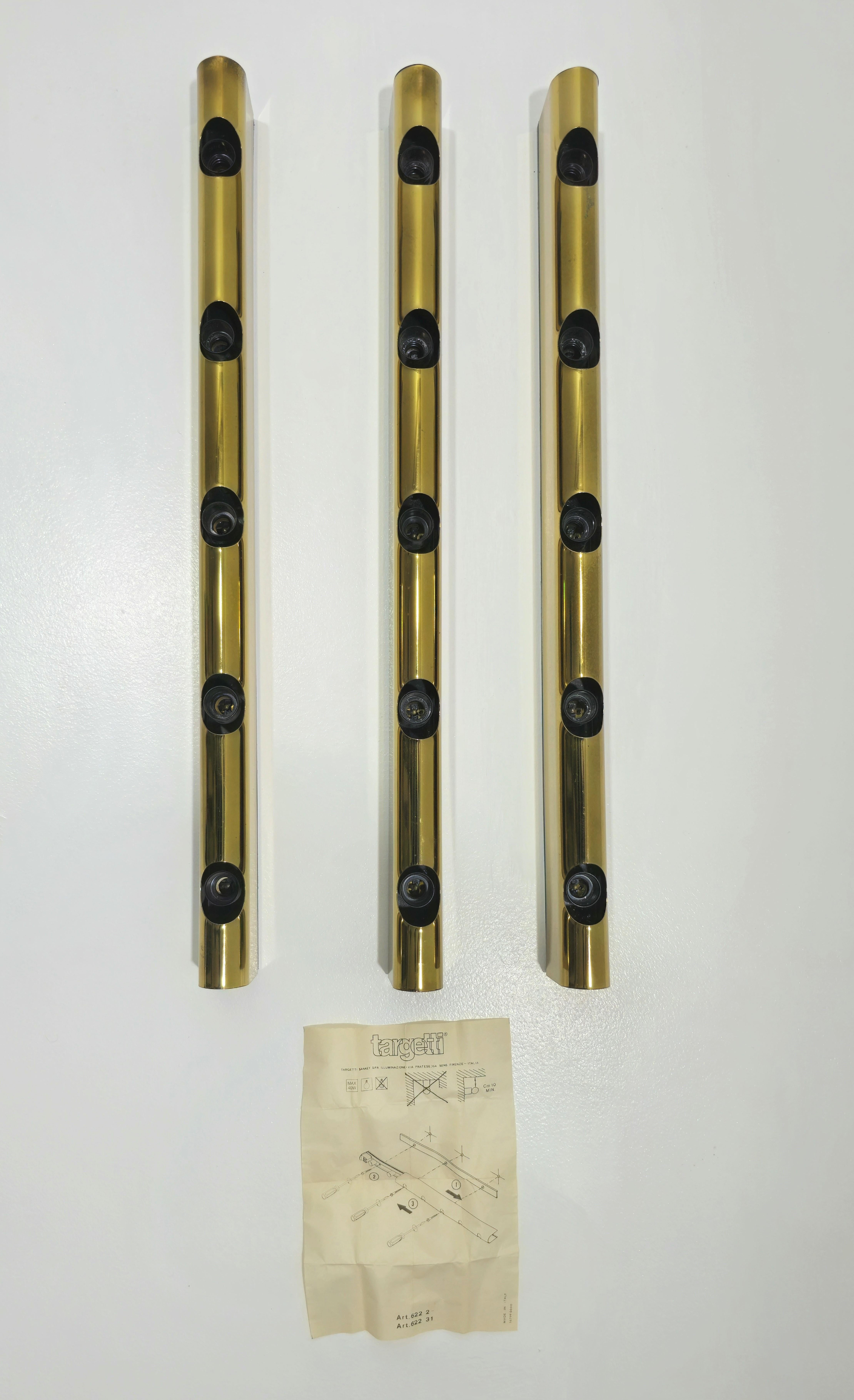 Lampade da parete di Studio Targetti prodotte in Italia, circa anni '70. Struttura in plastica, 5 luci e finitura in alluminio dorato. Facile da posizionare, è davvero un bel mobile. Label di produzione. Ti preghiamo di guardare attentamente il