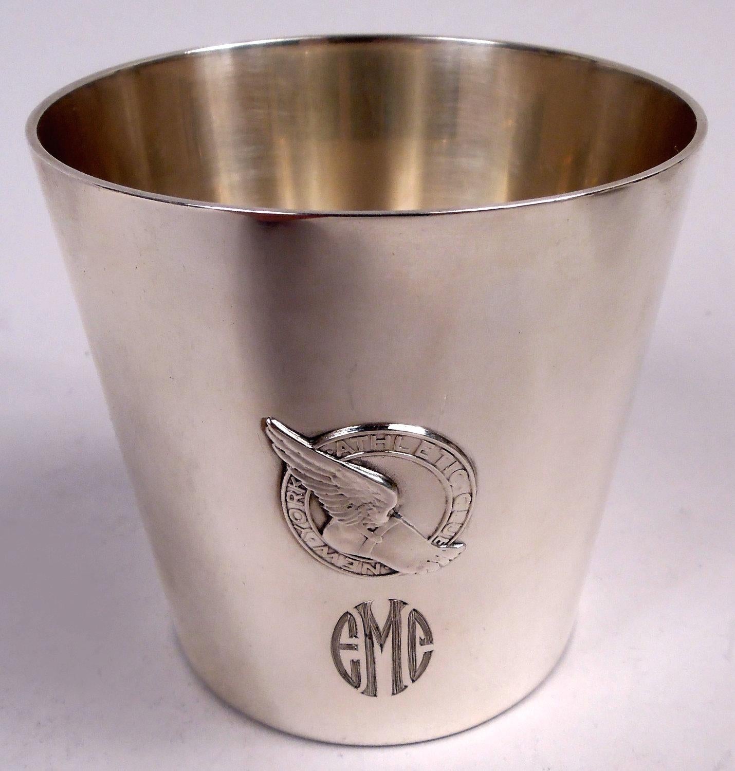 Set of 3 Modern sterling silver tumblers. Made by Tiffany & Co. in New York, ca 1941. Each: Straight and tapering sides. Applied emblem for the New York Athletic Club and engraved shaded monogram. On underside is engraved script presentation for
