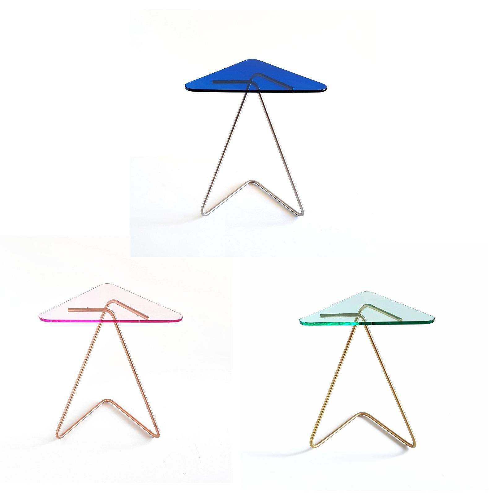 Set of 3 triangle side table by Rita Kettaneh 
Dimensions: The base: brushed stainless steel 
 optionally plated with copper or brass
 The top: acrylic
Materials: H 49.5 x W 41 x D 9.5 cm
Weight: 2.6 Kg

Colors and finishes:
Stainless