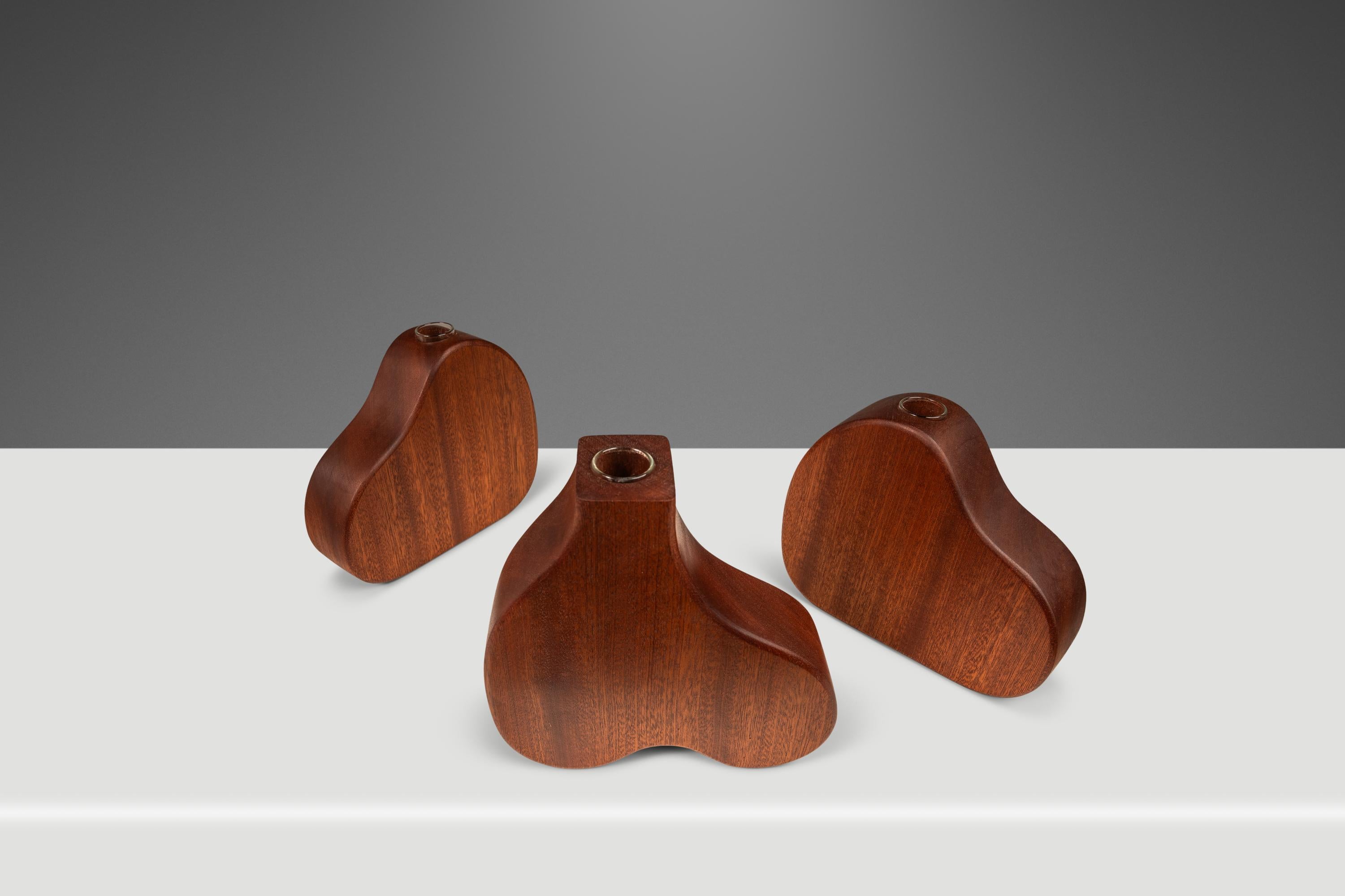 Dale a tu casa un toque de elegancia orgánica con este juego de tres jarrones para capullos/propagación diseñados y tallados por Mark LeBlanc para Leblanc Studios. Elaboradas con maestría a partir de Sapele africano macizo, raro y obtenido