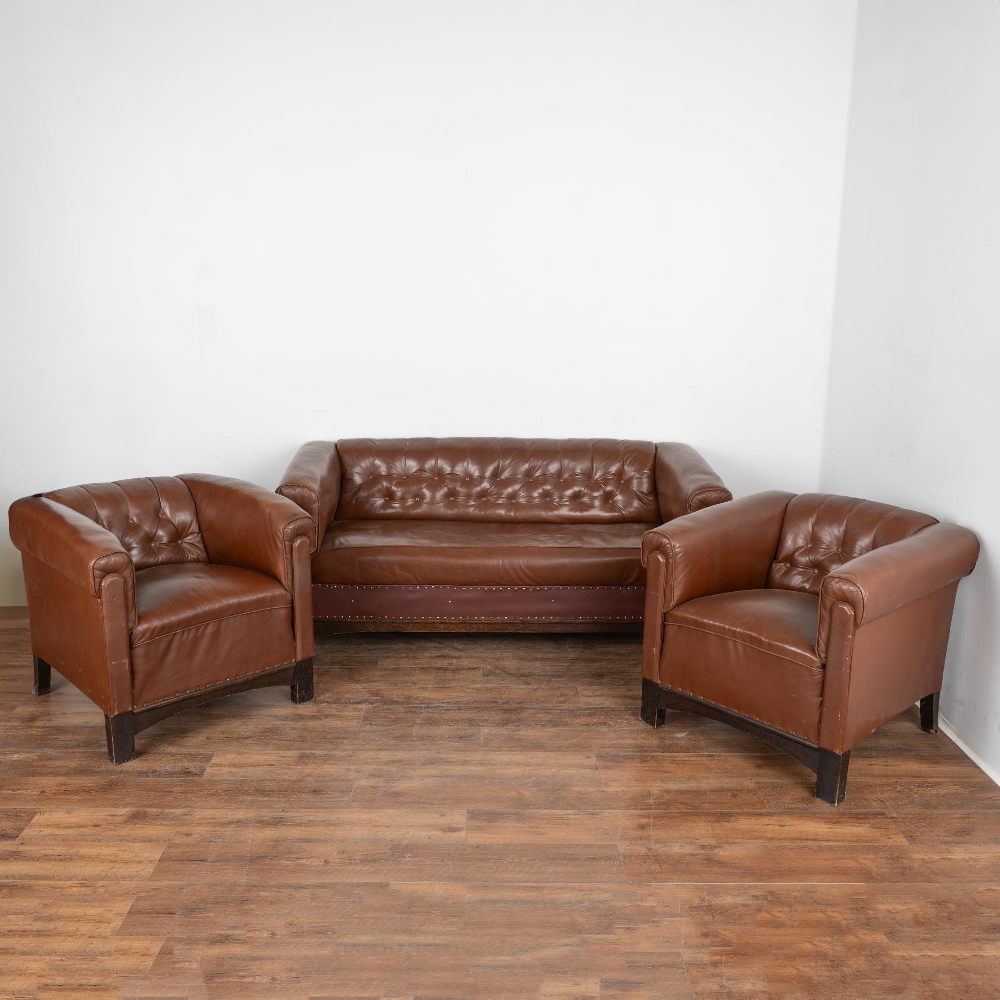 Set (3) vintage brown leather sofa and pair of club arm chairs.
Sold in original used vintage condition. The brown leather show scuffs, scratches, missing/recovered buttons, impressions, leather on front of sofa has been replaced (note different