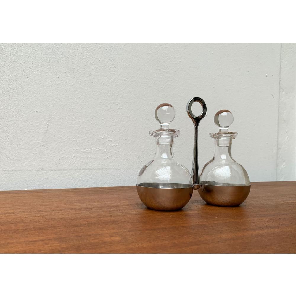 Menagere tedesco d'epoca per olio e aceto di WMF, anni '70, set di 3, in ottime condizioni. Disegnato dal 1970 al 1979 Questo pezzo ha un marchio di attribuzione.

Informazioni aggiuntive:
Materiali: Vetro, metallo
Colore: Argento
Paese di origine: