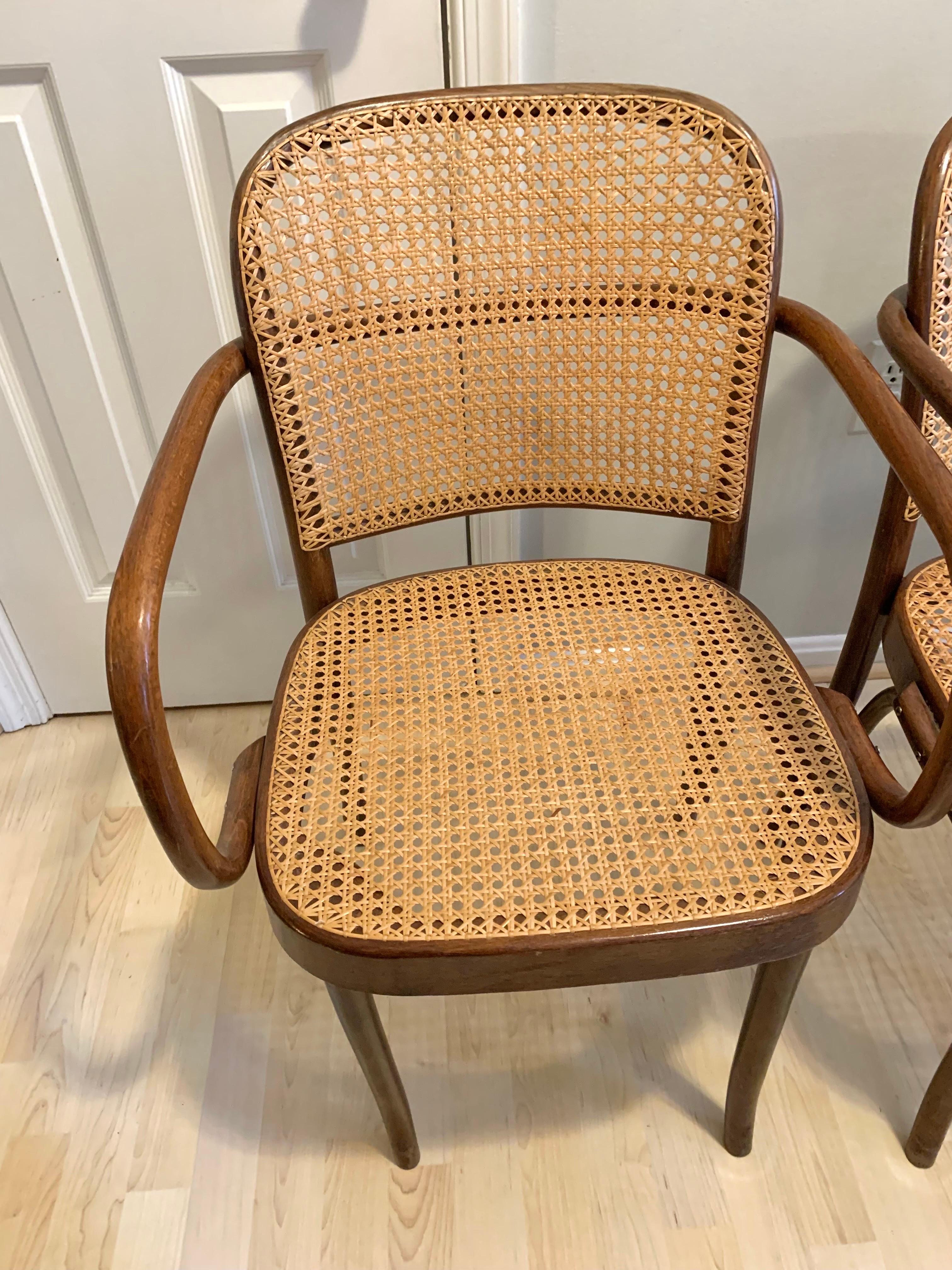Mid century Josef Frank and Josef Hoffman style bentwood Prague armchairs with caned seats and back. Walnut colored wood frames and handwoven caning.
