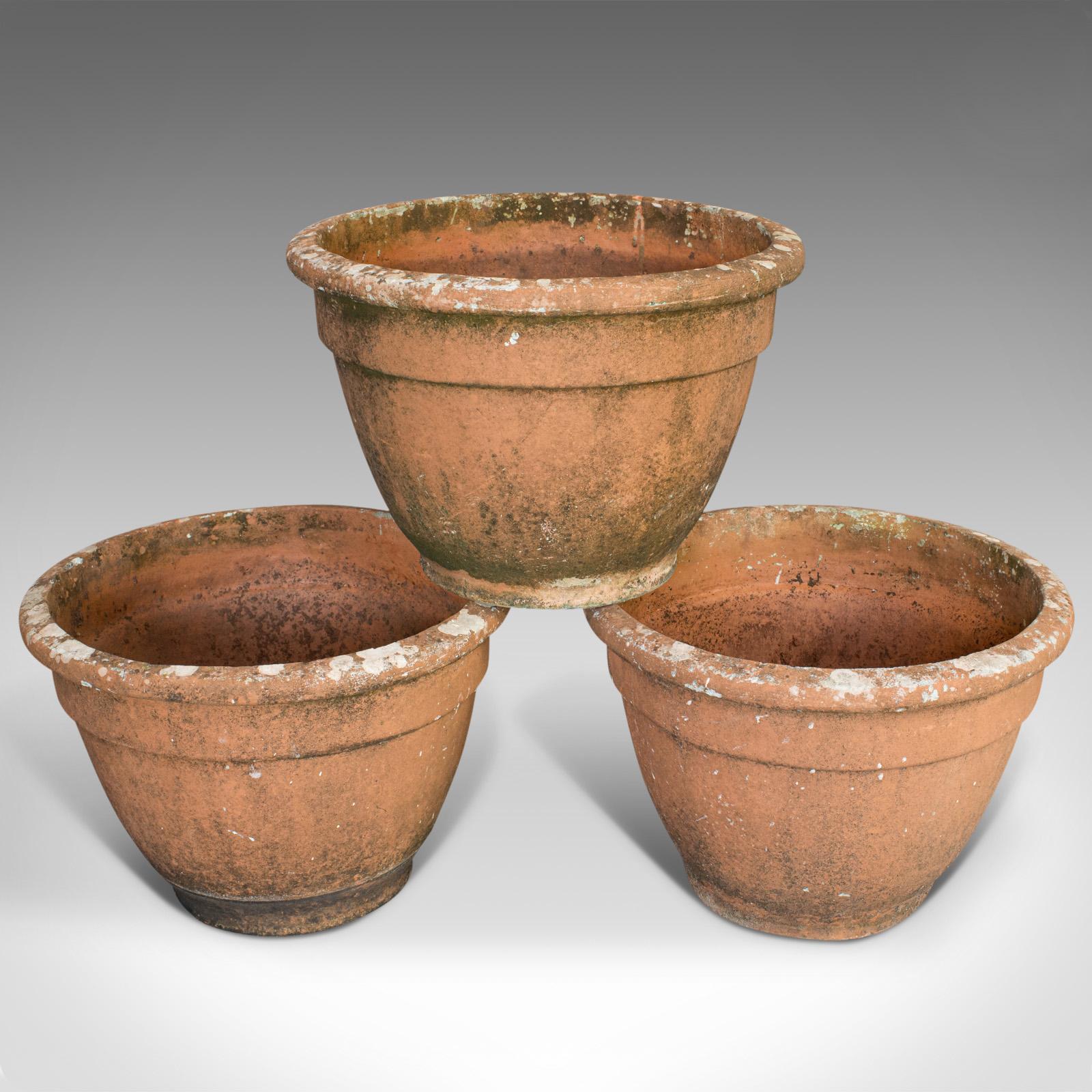 This is a set of three vintage planters. An English, terracotta large garden plant pot, dating to the 20th century.

Generously sized with appealing weathering
Displaying a desirable aged patina
Terracotta in good order with pleasingly natural