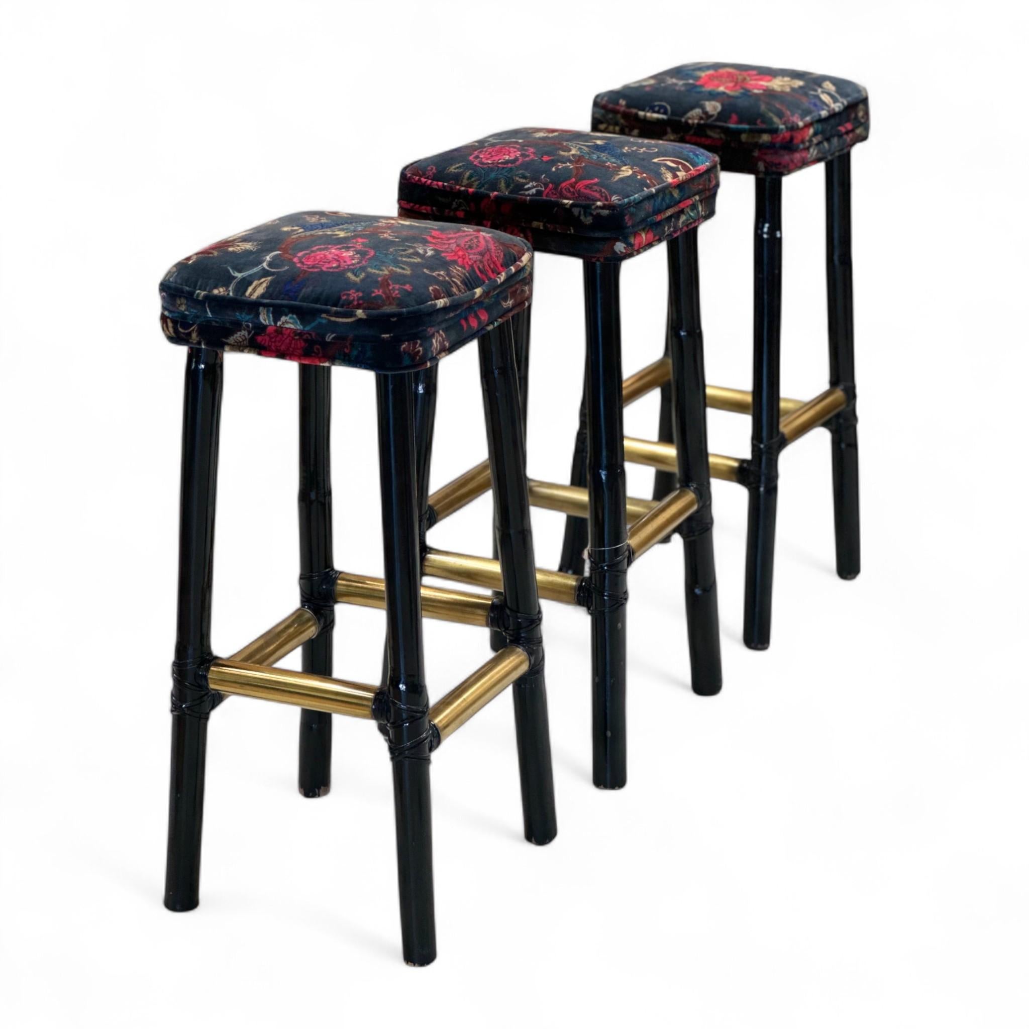 Un ensemble saisissant de trois tabourets de bar vintage dotés d'un riche revêtement en velours à motifs floraux. Les pieds en bambou laqué noir et les brancards en finition laiton ajoutent une touche de glamour et de sophistication.