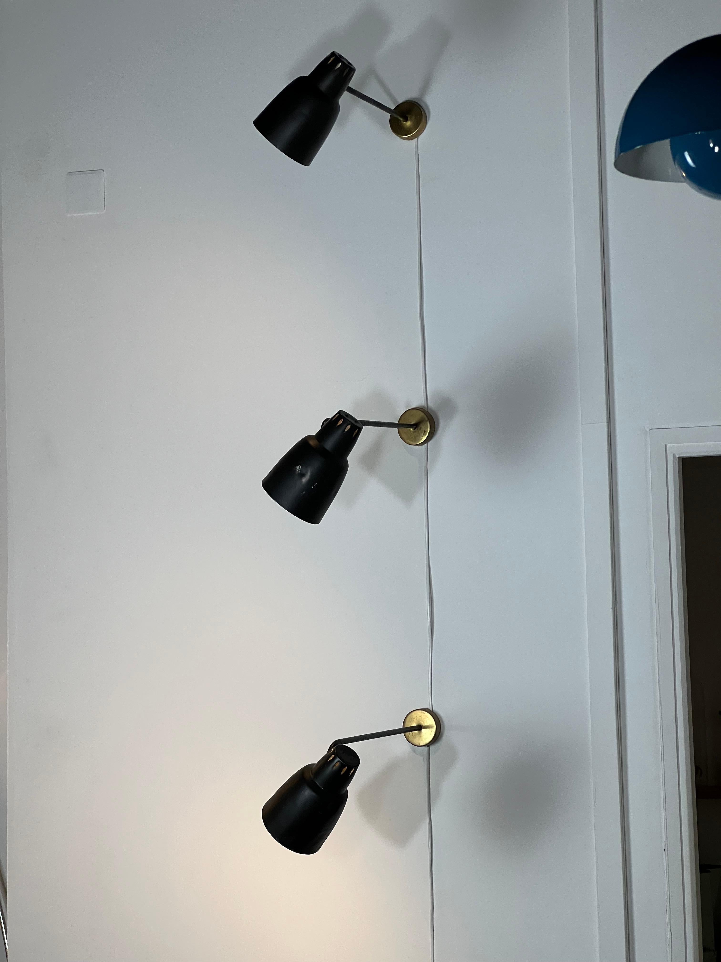 Wall lamp from the 1950s, edited by the French company Parscot.
Its structure is composed of a golden aluminium plate allowing its fixing to the wall. The fixing is extended by a black metal bent tubular arm.  The diffuser is directly connected to