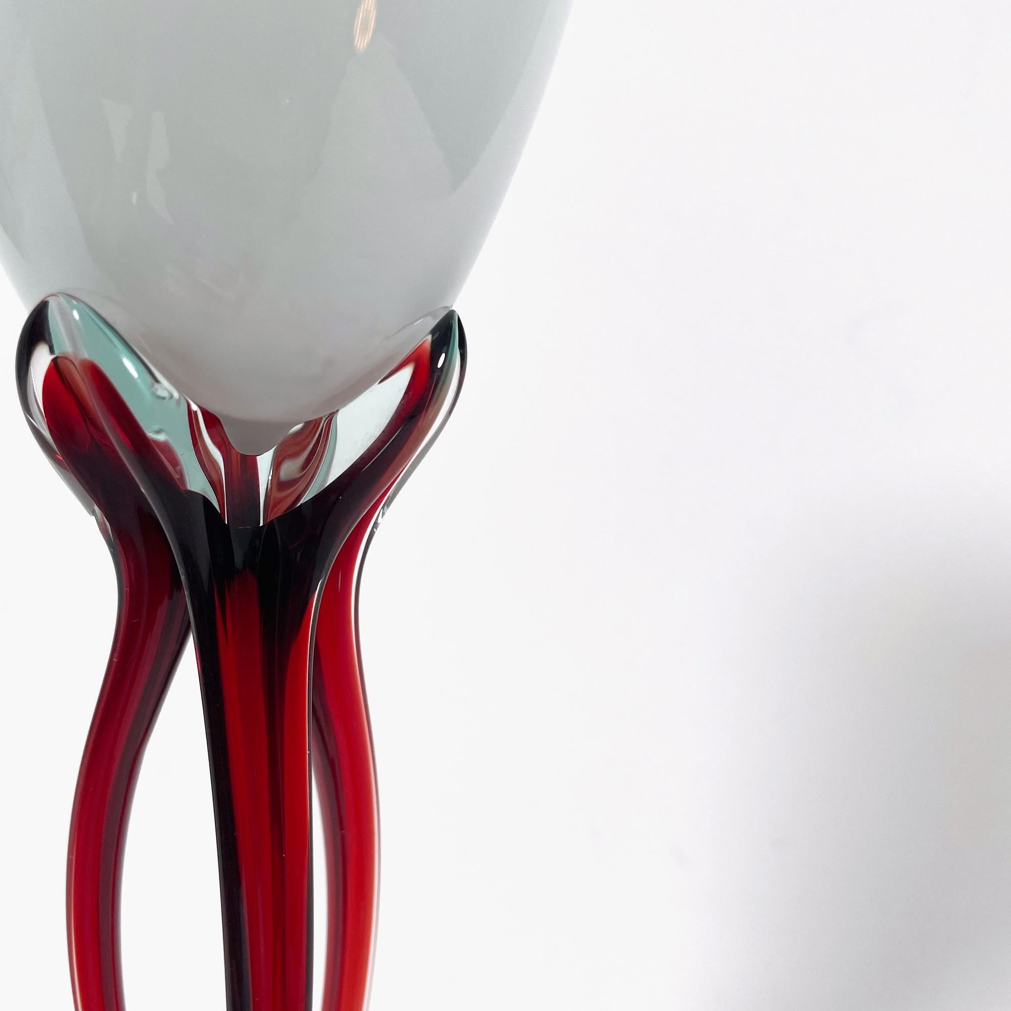 Añade un toque de arte y elegancia a tu mesa con este juego de 3 exquisitas copas de pez de cristal soplado de Murano. La llamativa combinación de tonos blancos y rojos crea un efecto visualmente impresionante, que recuerda a la renombrada tradición