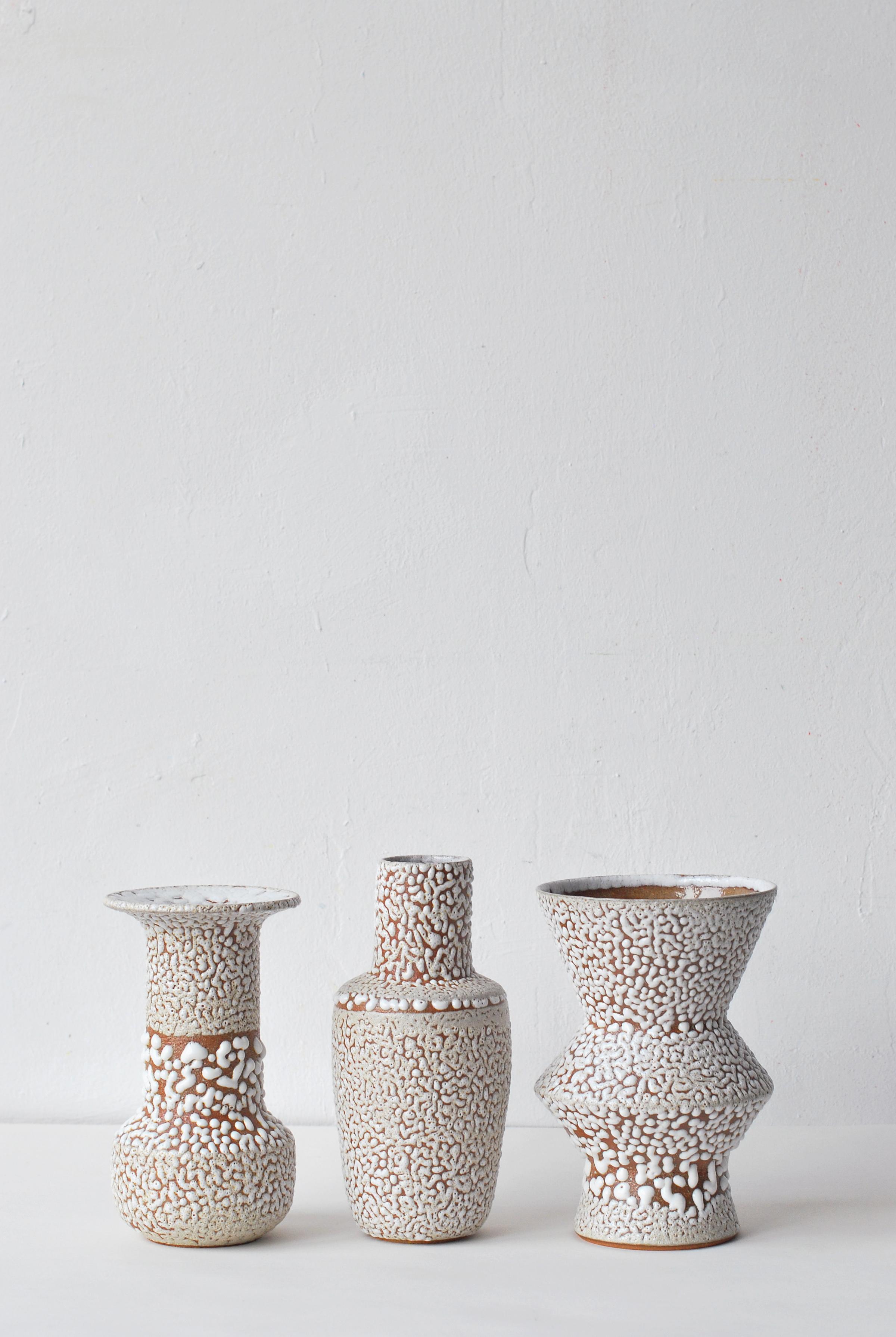 Set of 3 white stoneware vase by Moïo Studio.
Dimensions: 17 x 9 x 9 cm
 16 x 6 x 6 cm
 17 x 7 x 7 cm
Materials: White crawl glaze on tan stoneware

Is the Berlin-based ceramic art studio of French-Palestinian artist Maia Beyrouti. It was