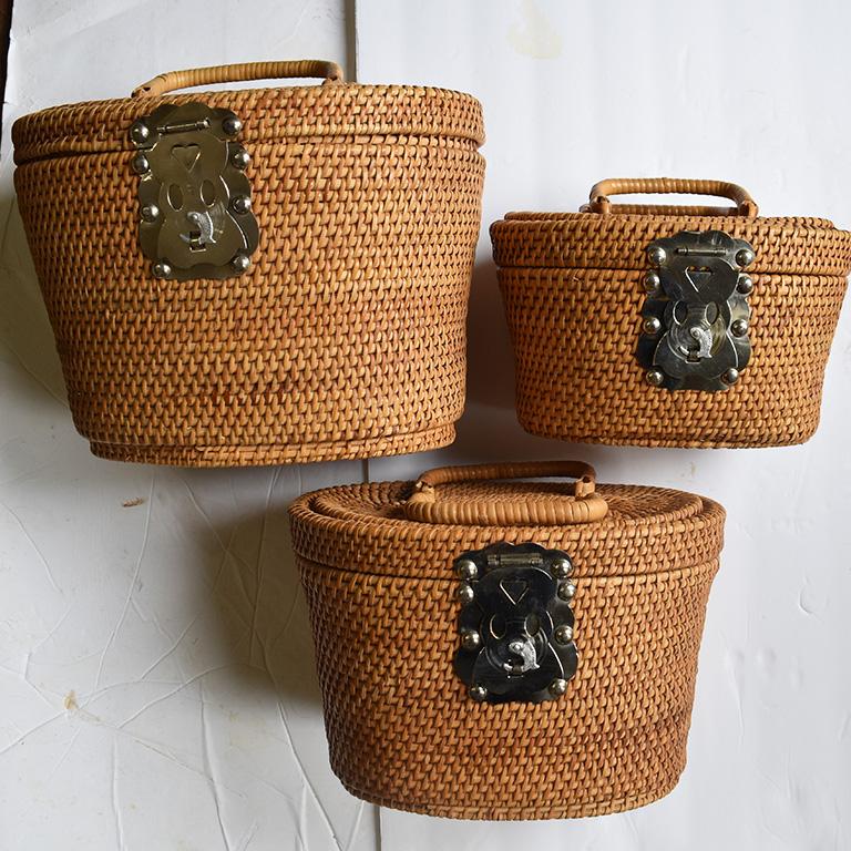 Beautiful set of three wicker Asian fishing baskets. Each basket fits one inside the other. This set was made in Hong Kong, circa 1960. The baskets feature chrome metal hardware on both the front and back in detailed Chinese patterns. Each basket