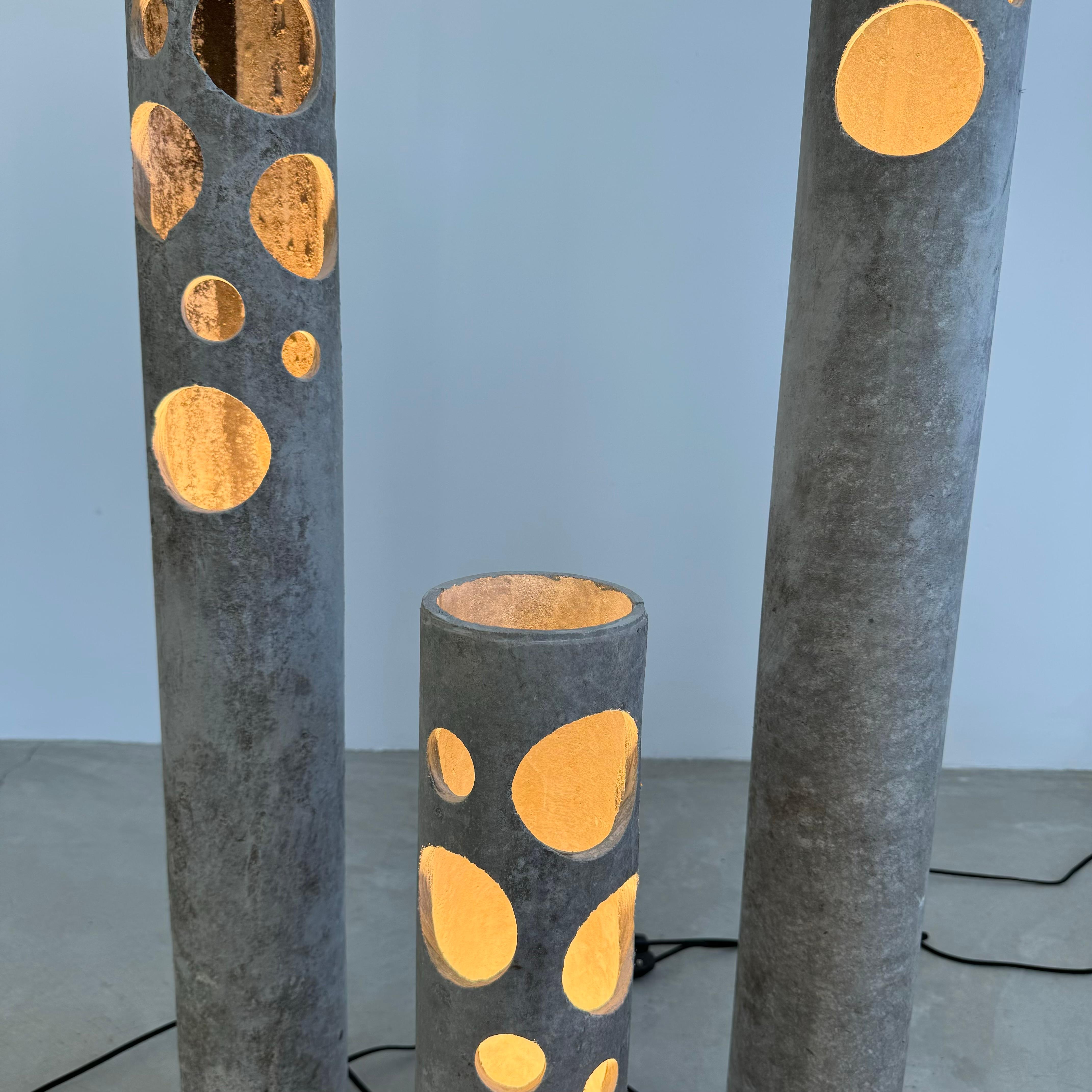 Fantastic and rare concrete lamps by Willy Guhl for Eternit. Circular cutouts allow light through and add to the design. One bulb inside each with on/off switch on the cord. Lovely soft grey color with subtle patina. Indelible presence. Mounted to a