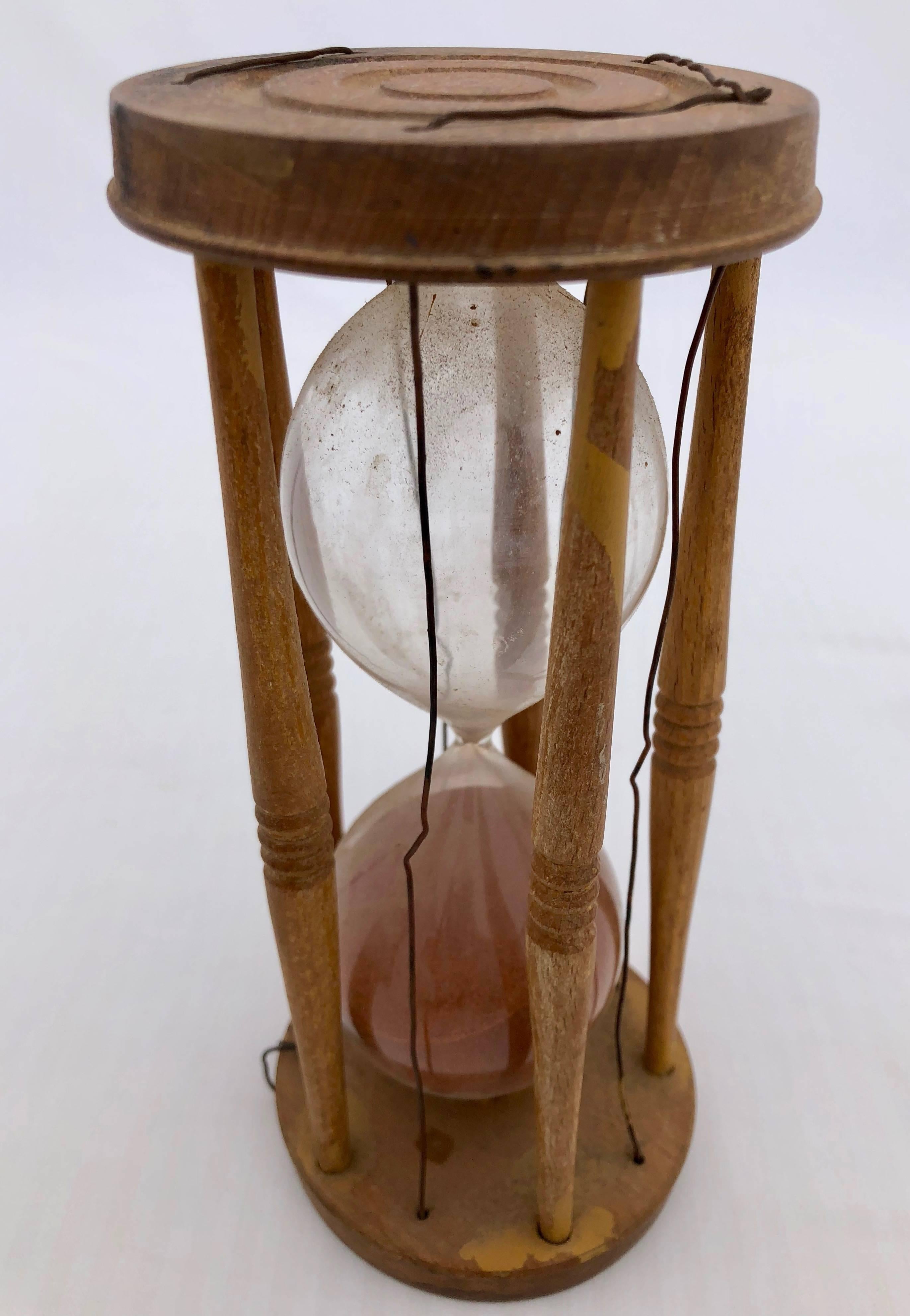 These beautiful sand timers are from the Empire period and have round wood frames, tapering turned wood spindles and handblown glass filled with red sand. Each of the wood frames are hand carved, one is reinforced with old wire.
Such sand timers