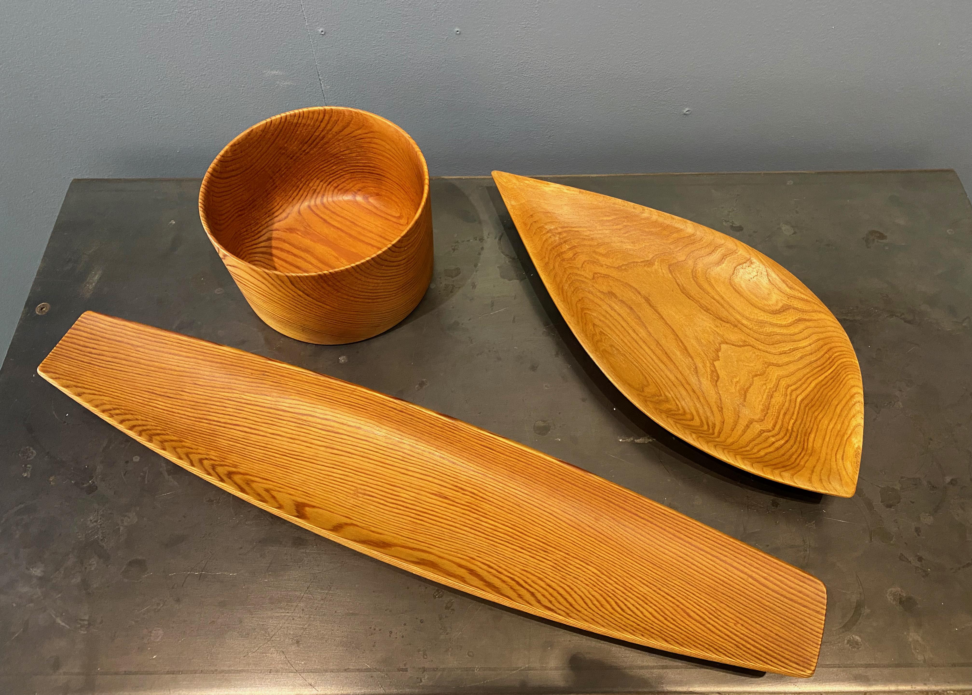 Set of 3 handcrafted wooden objects by Swedish craftsman Sven Erik Lindman.  The long, shallow bowl (oregon pine) measures 60,5 cm (lengt), 12,5 cm (width) and 3,5 cm (height). Signed by the craftsman, 1959).
The leaf shaped bowl (probably teak)