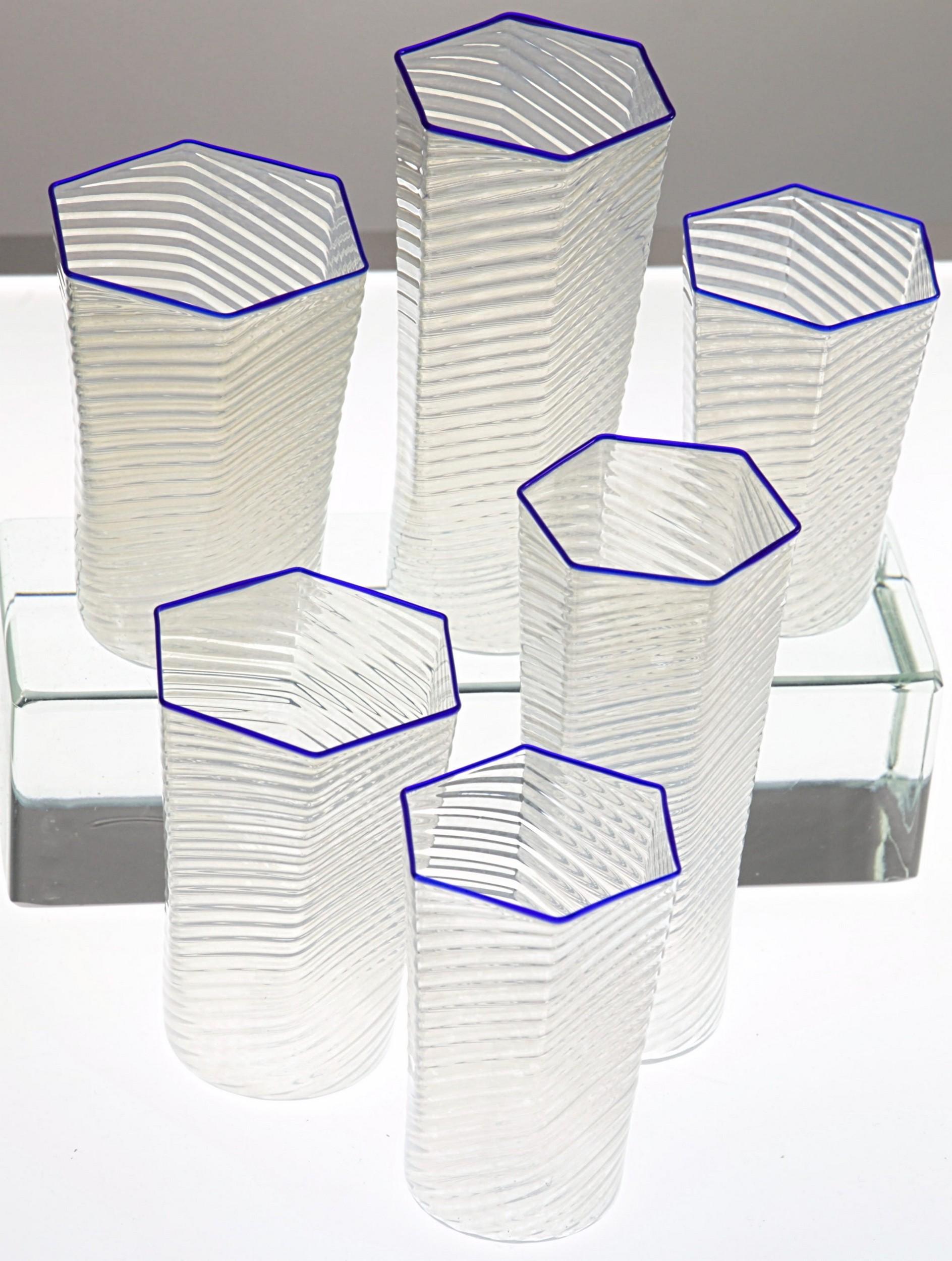 Incredible set of 30 hexagonal light glasses finely ribbed in spirals. It's called rigadin ritorto or mena' in Muranese glass world. Cobalt blue rim.

Extremely light. Egg skin thickness. Very elegant and incredible to touch and weight. A perfect