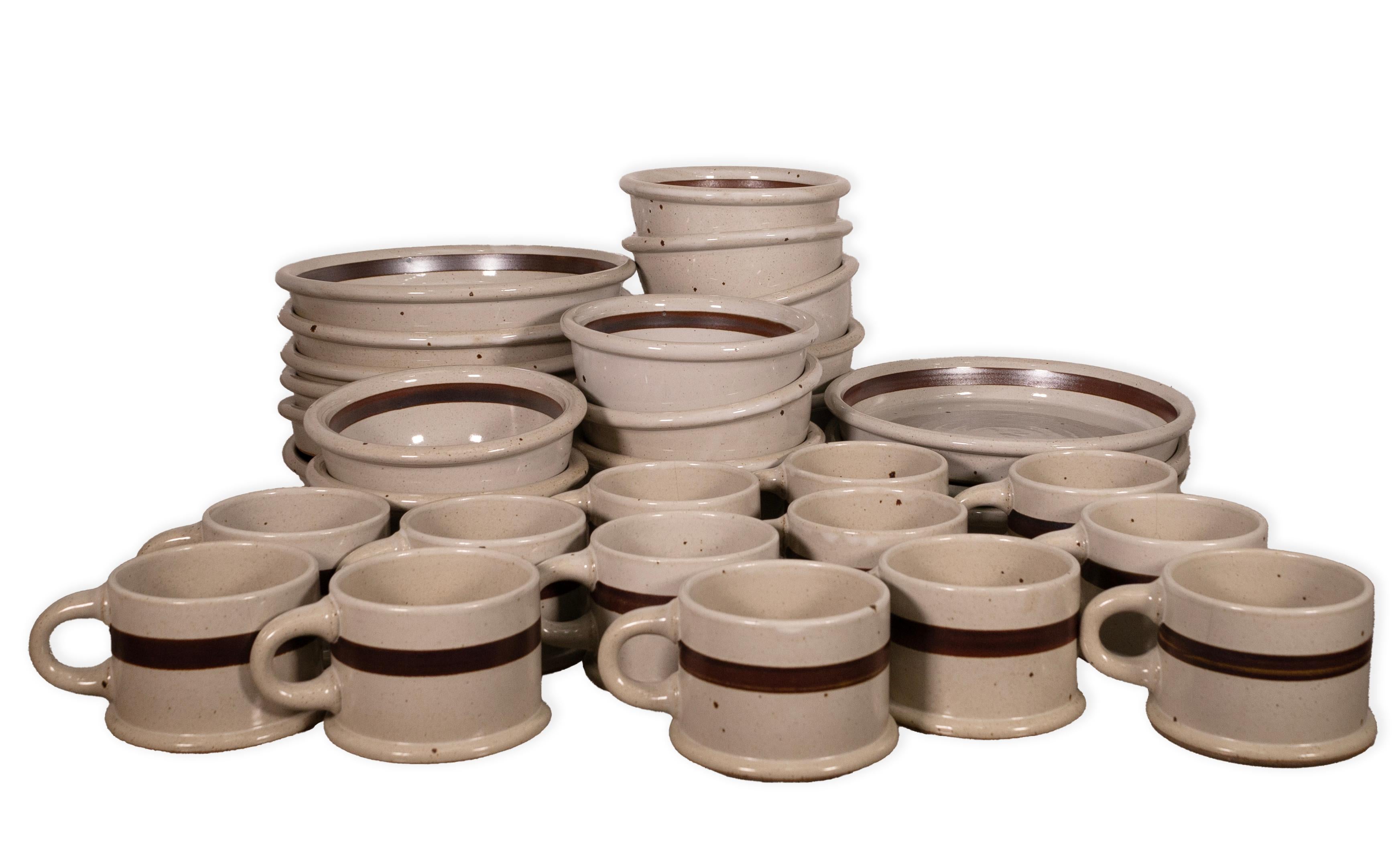 Un set di piatti Dansk BLT Sandstone da 32 pezzi. Questo splendido set di piatti comprende 13 tazze, 10 ciotole e 9 piatti. Questo set risale al 1980 circa e presenta un bellissimo stile di metà secolo con il suo colore di base bianco sporco, le