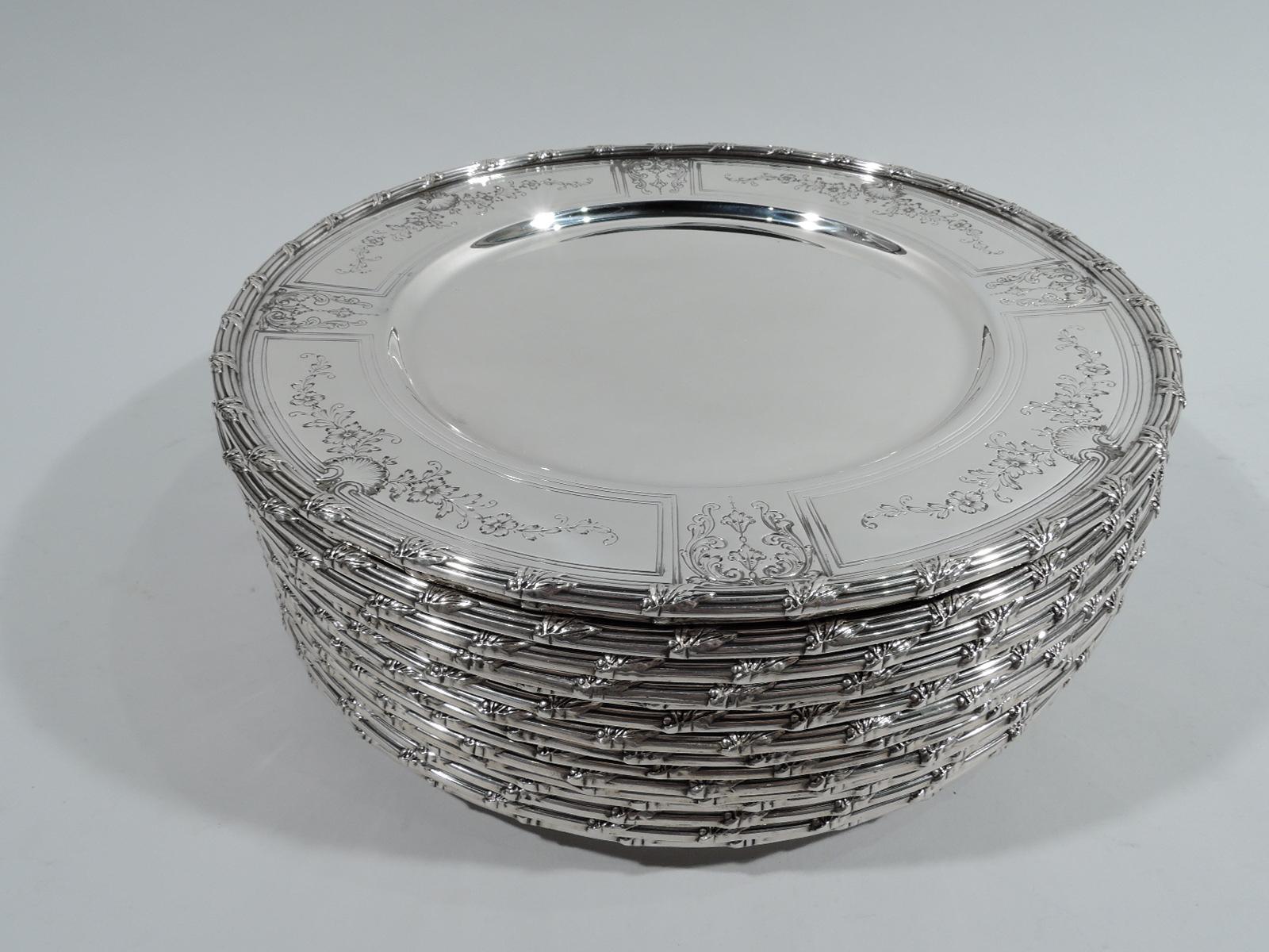 Set of 32 Edwardian sterling silver plates. Made by Durgin (part of Gorham) in Concord, 1927-1929. This set comprises 16 dinner plates and 16 bread and butter plates. Each: Round plain well and tapering shoulder with framed garlands and shells