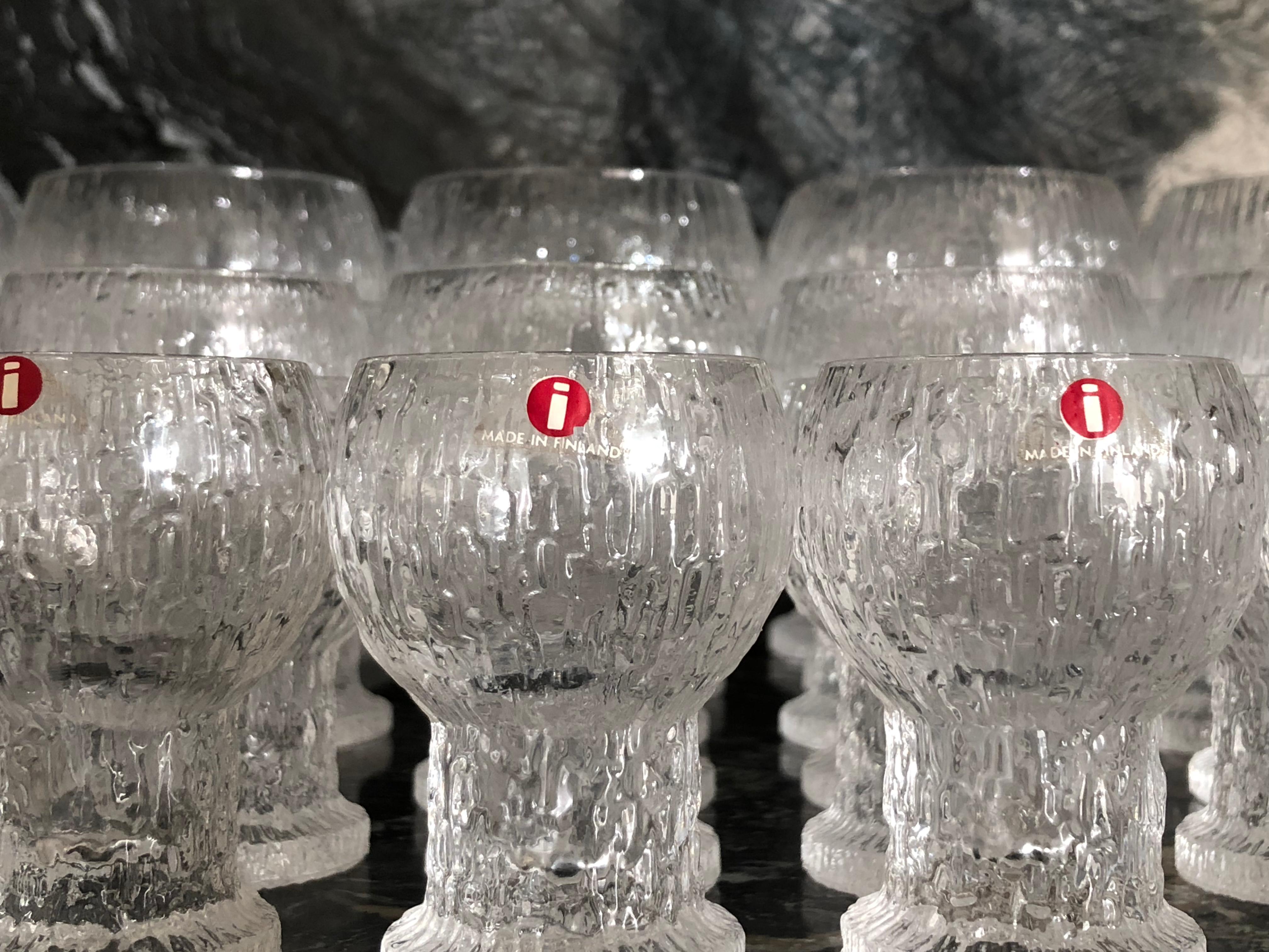 A set of 36 Finnish 'ice bark' glasses designed by Timo Sarpaneva and made by Iittala. The service for twelve consists of 12 wine goblets, 12 port or sherry glasses, and 12 liquor or schnapps glasses which also work well as sake glasses. 
These are