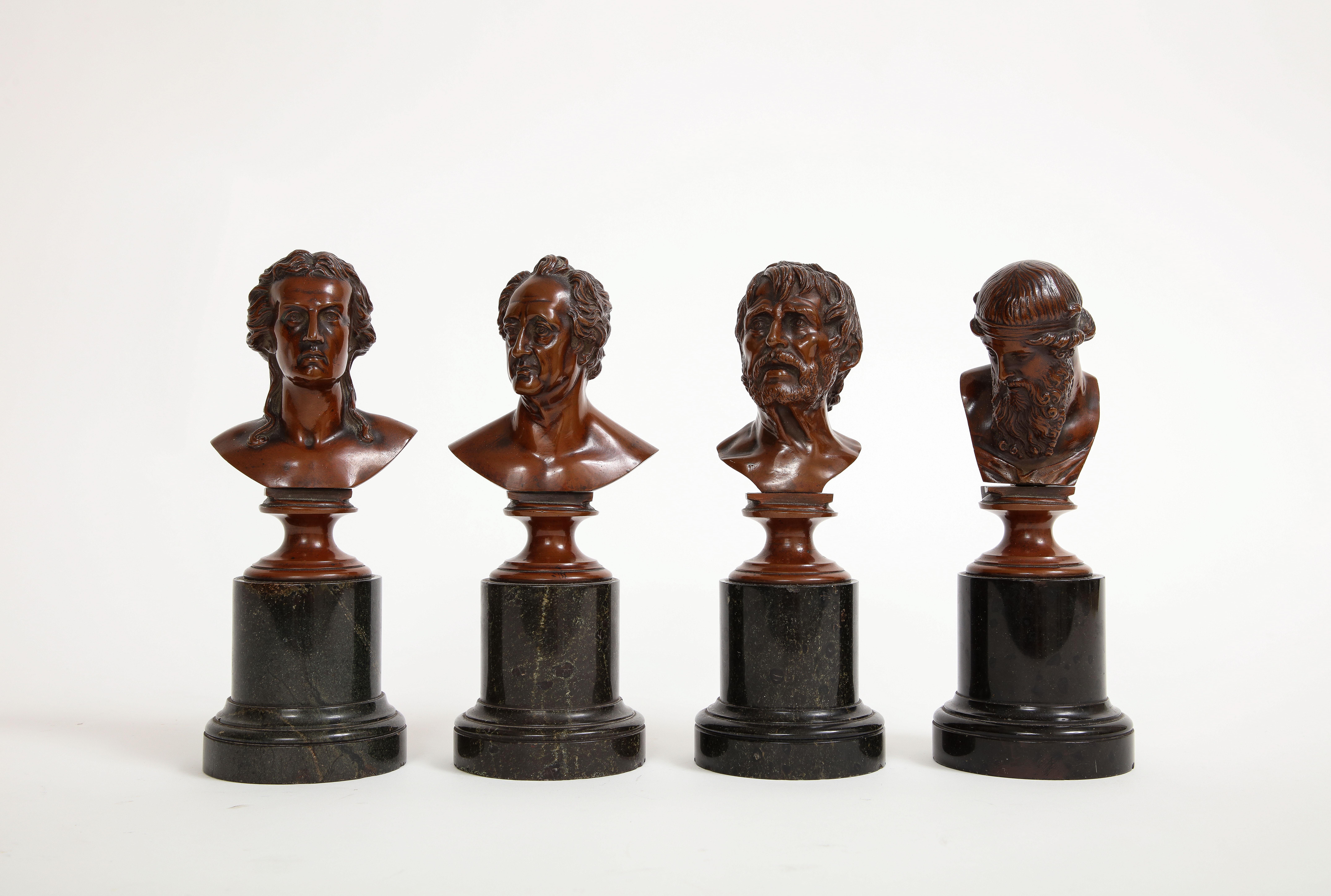 A Set of  Four 19th Century French Patinated Bronze Marble Mounted Busts of Philosophers.  The stunning patina adorning each bust accentuates the intricate facial expressions, breathing life into the features of these esteemed scholars and