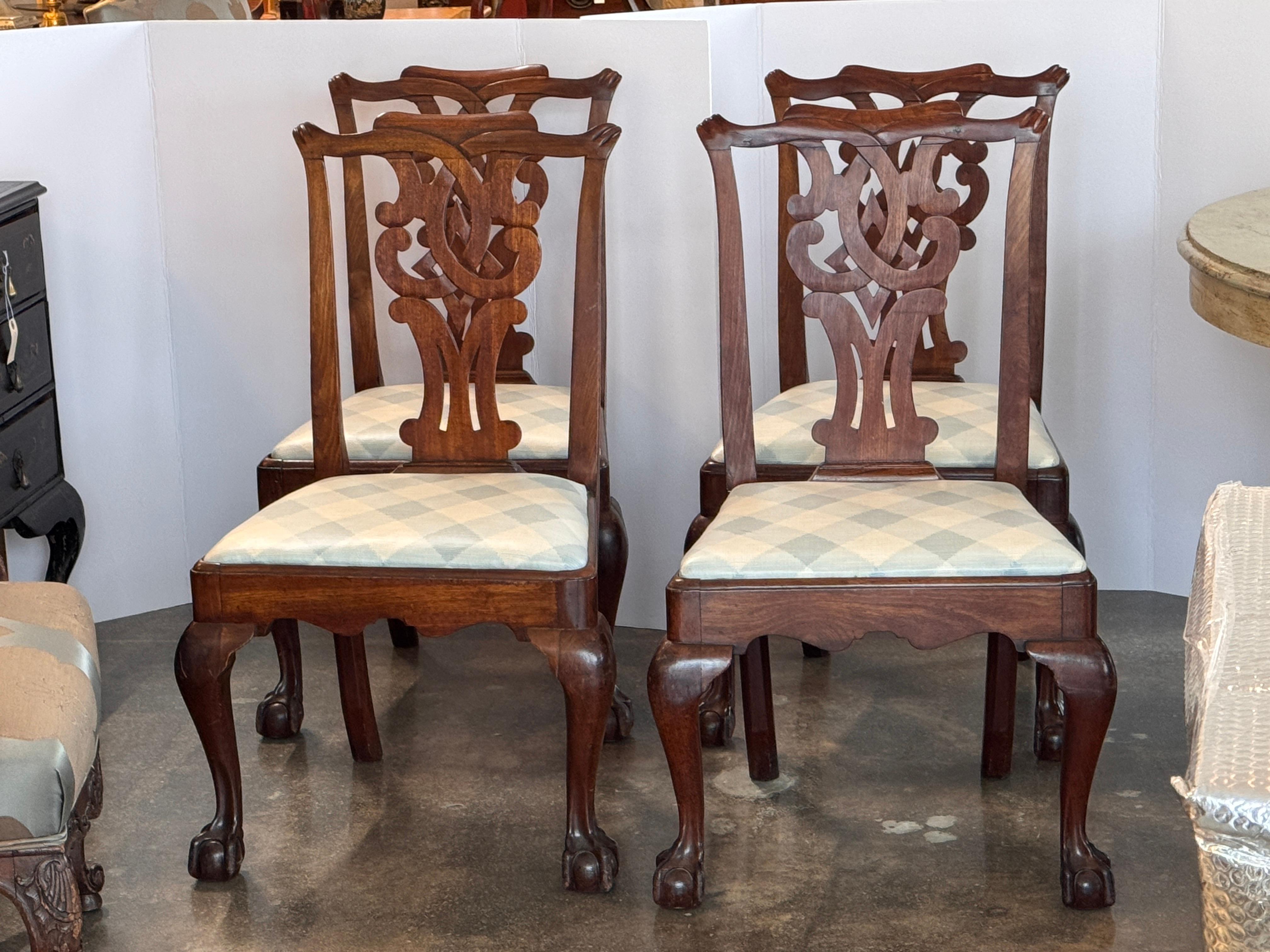 Set of four English chairs in mahogany with pierced splats and cabriole legs terminating in carved claw-and-ball feet, shown clearly in the detail image. Each chair has a shaped seat rail and upholstered seat.