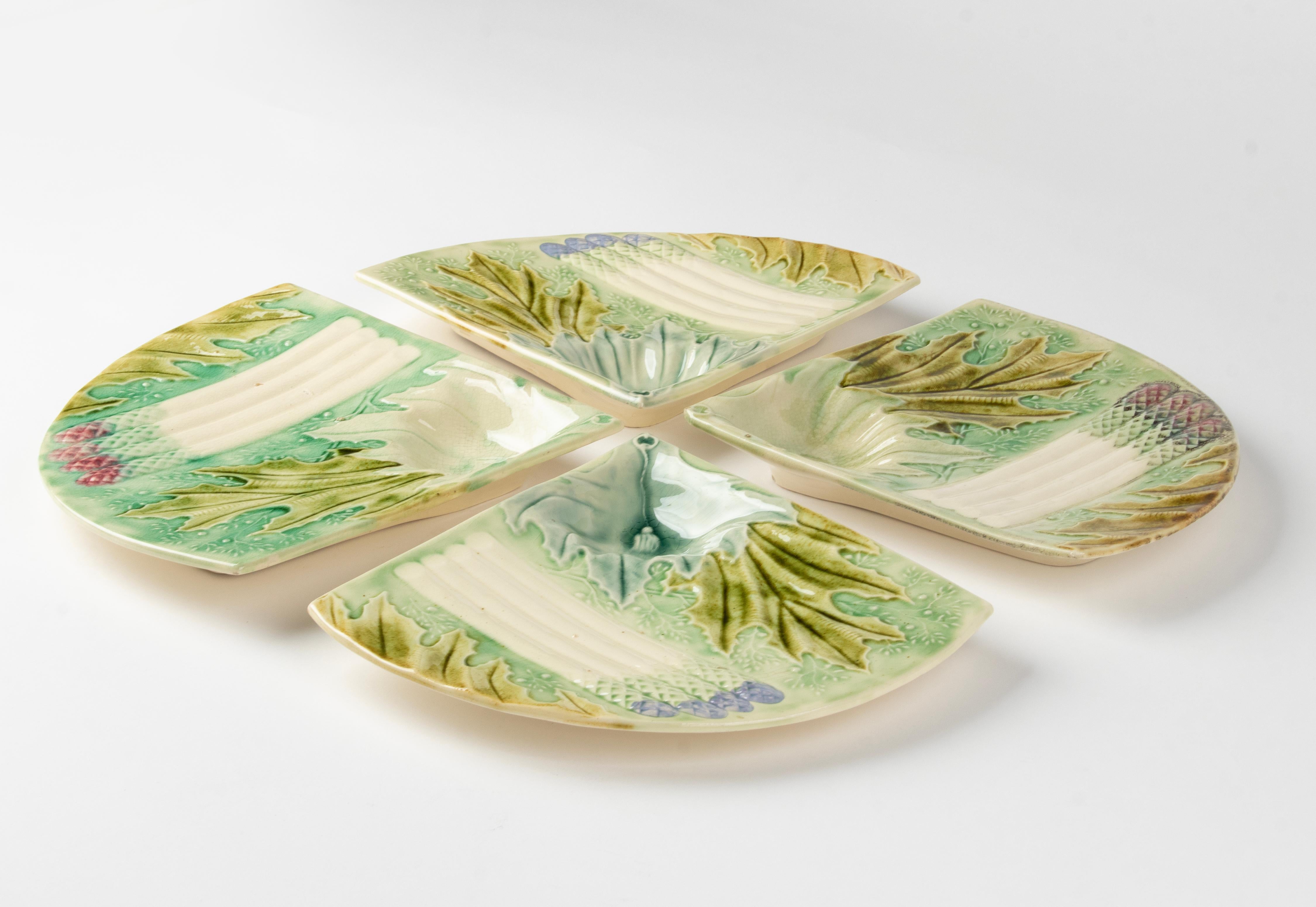 Beautiful set of four majolica ceramic plates for serving asparagus. The plates have a special shape and are decorated with bright colours. The plates are not marked, maker unknown, presumably French. On plate has an imperfection on the corner, it
