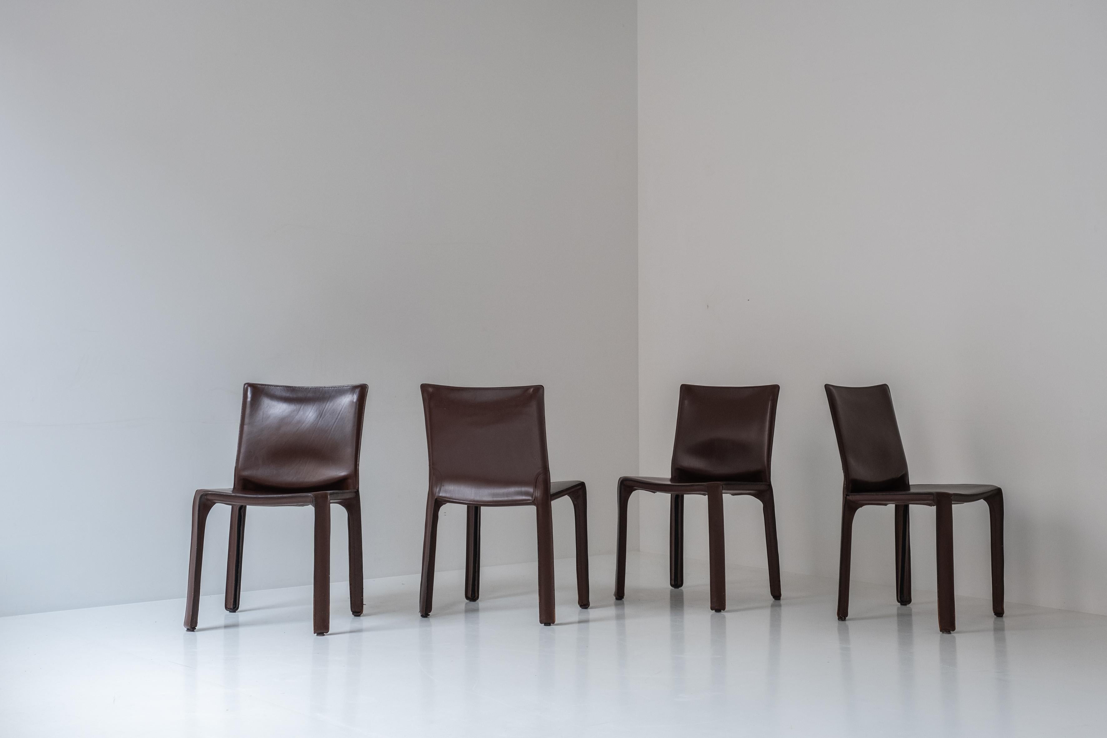 Set of four ‘413’ CAB dining chairs by Mario Bellini for Cassina, Italy 1977. These chairs features a handstitched brown leather upholstery wrapped over an internal steel frame. Well presented original condition with a nice overall patina. Labeled