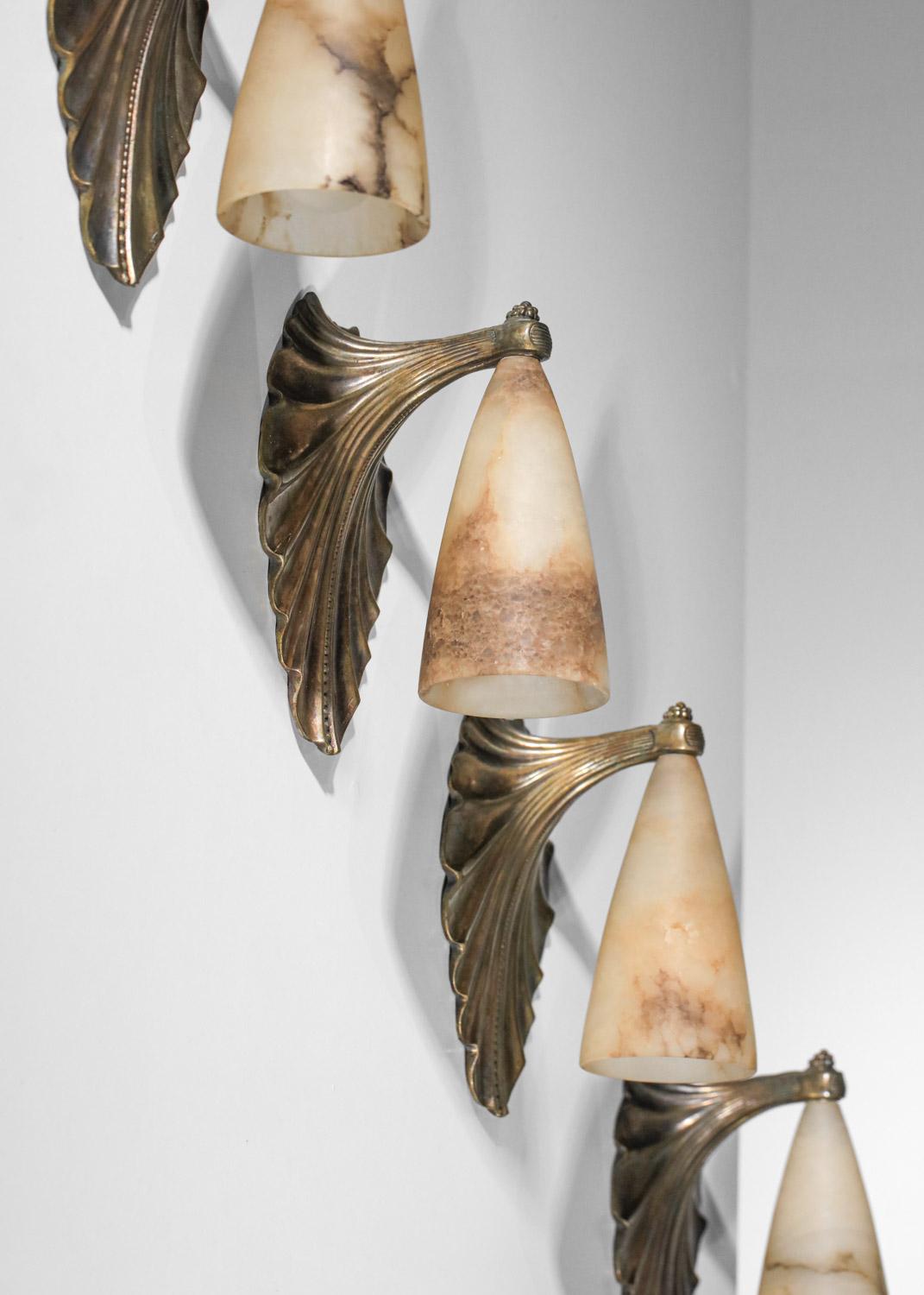 Superb set of four art deco wall sconces by French designer Albert Cheuret dating from the 1930s.  Solid bronze structure and alabaster conical shades. Very fine vintage condition, with a beautiful patina of age on the bonze (see photo). Designer's