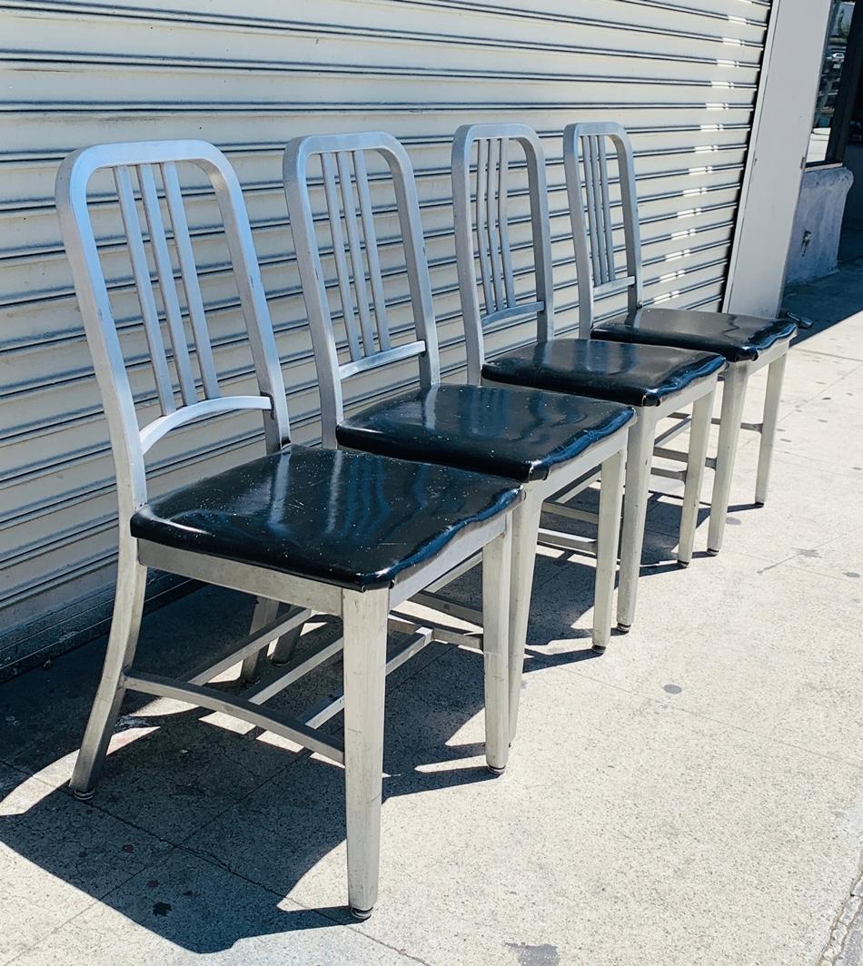 Set of 4 aluminum chairs from the 1950s or earlier, designed and manufactured in the USA by Goodform.

The chairs are very lightweight, the seats are upholstered in black vinyl which is original to the chairs.

3 are an exact match and the