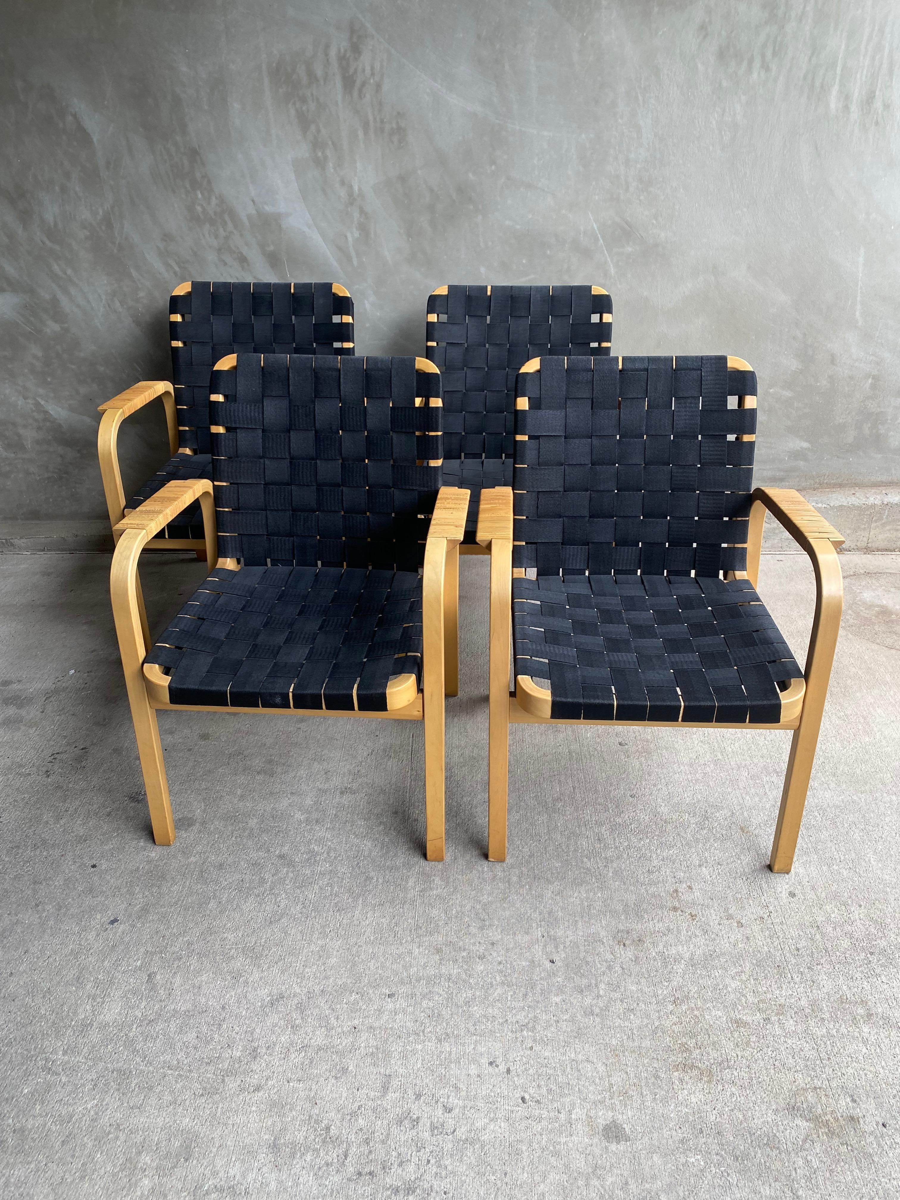 Set of 4 Model number 45 armchairs, designed in 1947 by Alvar Aalto and manufactured later (1960's?) by Artek. Beech frames and woven black nylon seat and back make a comfortable and sought after combination that is iconic to the mid-century modern