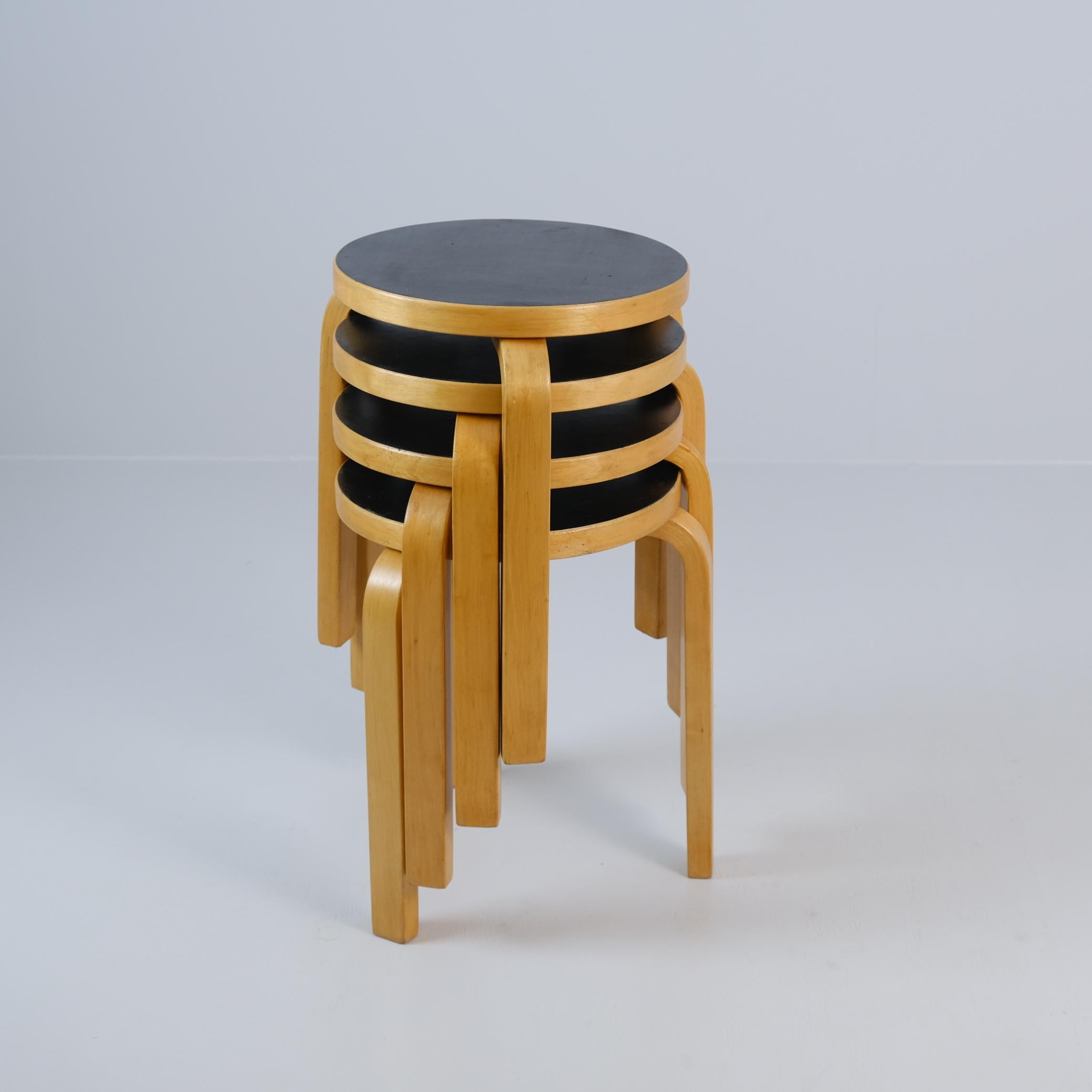 Ein Satz von 4 Alvar Aalto Modell 60 Hockern aus Birke und schwarzem Laminat, entworfen von Alvar Aalto in den 1930er Jahren, hergestellt von Huonekalu- Ja Rakennustyötehdas Oy in Finnland und weltweit vertrieben von Artek. 

Diese ikonischen Hocker