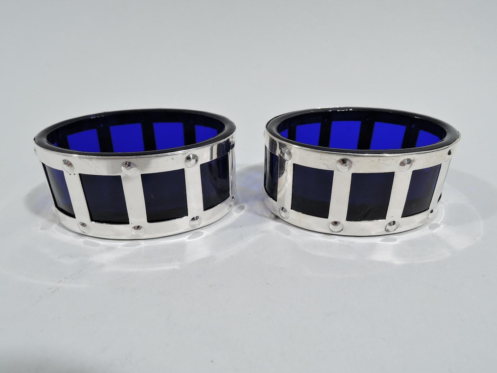 Set of 4 sterling silver open salts. Made by Webster in North Attleboro, ca 1925. Each: Oval with open bottom. Sides straight with open rectangles studded at corners. Detachable cobalt glass liner. Fully marked.