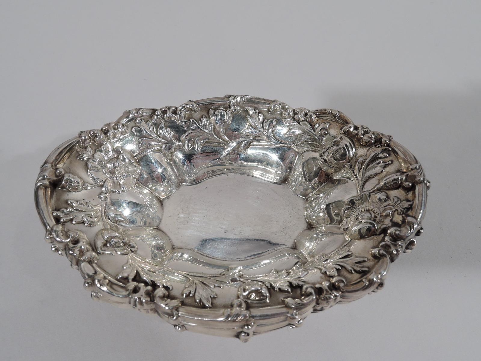 Set of 4 turn-of-the-century Art Nouveau sterling silver nut dishes. Made by Meriden Britannia (part of International) in Connecticut. Each: Boat-form with shaped oval well. Sides lobed with chased strewn flowers and scrolled rim. Fully marked and