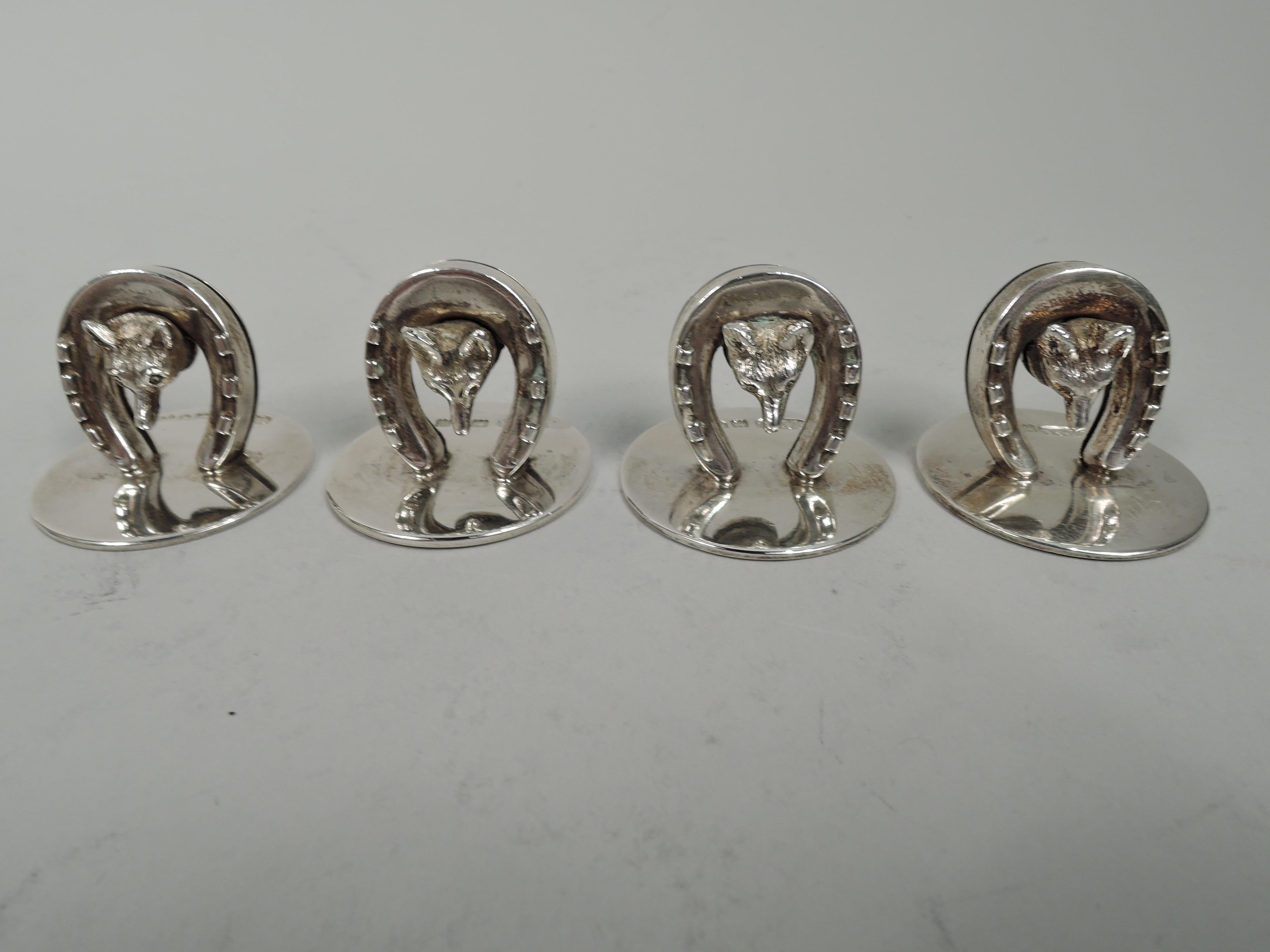 Set of 4 Edwardian sterling silver place card holders. Made by Charles & George Asprey in London, 1906 to 1908. Each: A cast fox head pokes through a horseshoe clip; round and flat base. In leather-bound case with silk and fitted-velvet lining.