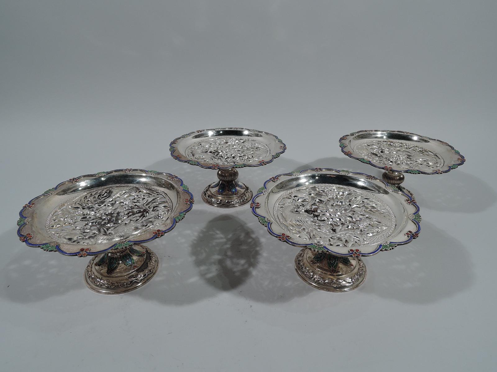 Set of 4 Southeast Asian export silver compotes, circa 1920. Each: Shallow bowl with pierced and chased birds and flowers. Enameled rim with raised scallops interspersed with berries and leaves. Support has ribbed knop. Foot raised with applied