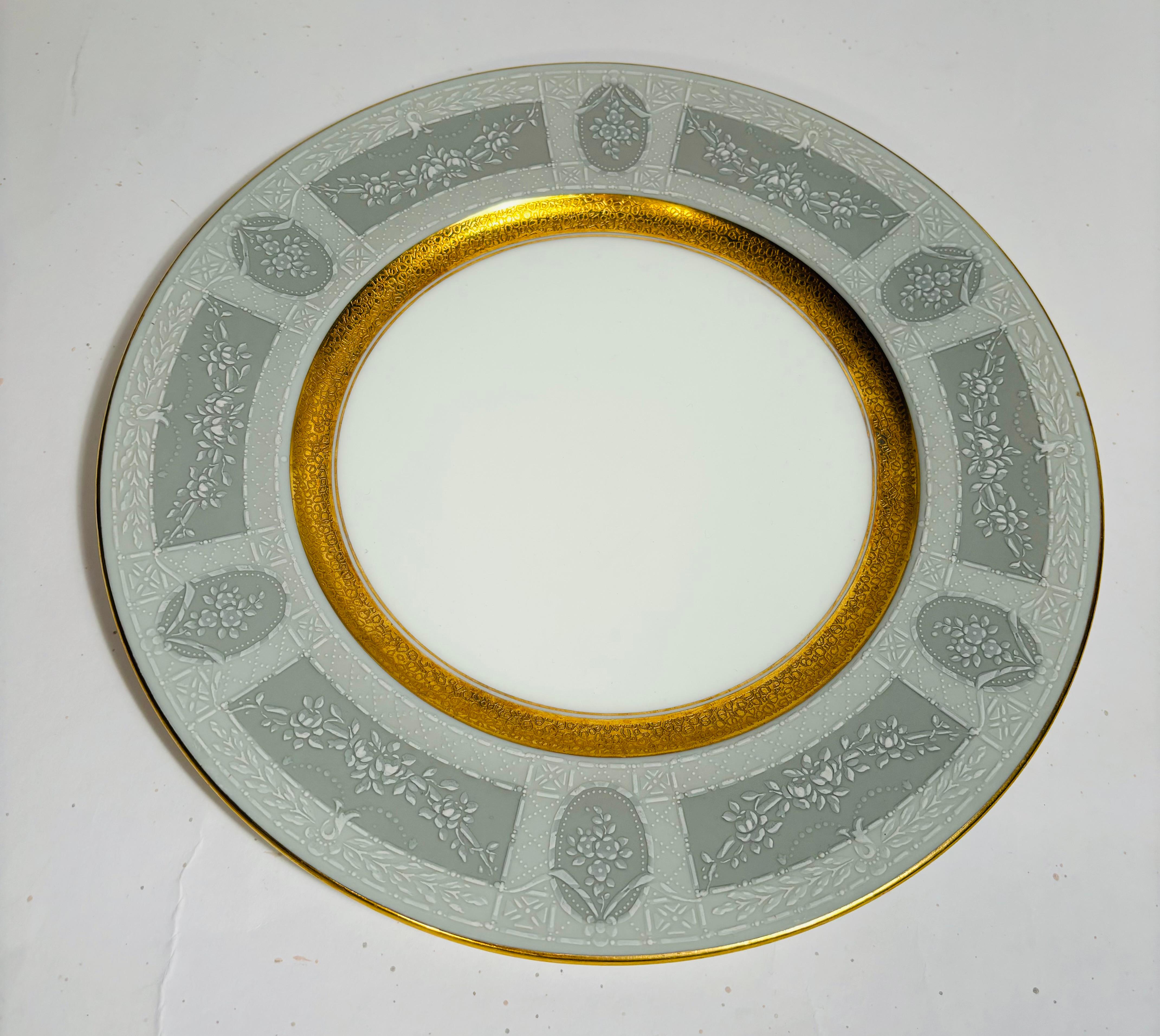 An elegant set of 4 antique dinner plates with a nice detailed pattern in the soft grey collars and trimmed with 24 karat gold and featuring a wider gold band in the center surround. In wonderful antique condition and ready to mix and match in with