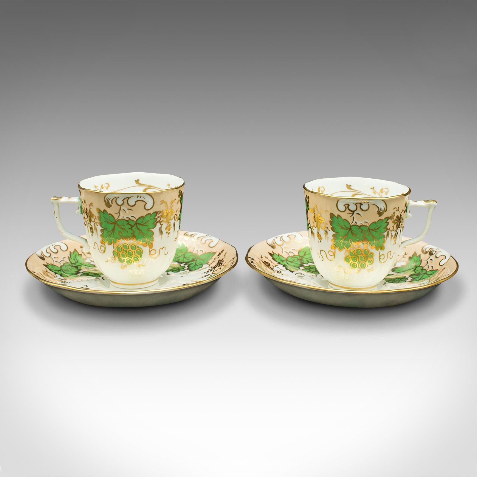 Dies ist ein Satz von 4 antiken Kaffeetassen. Eine englische, dekorative Trinkkanne und Untertasse aus Bone China mit grünem Traubenmuster aus der viktorianischen Zeit um 1850.

Wunderschön verziert und angenehm in der Hand liegend
Zeigt eine