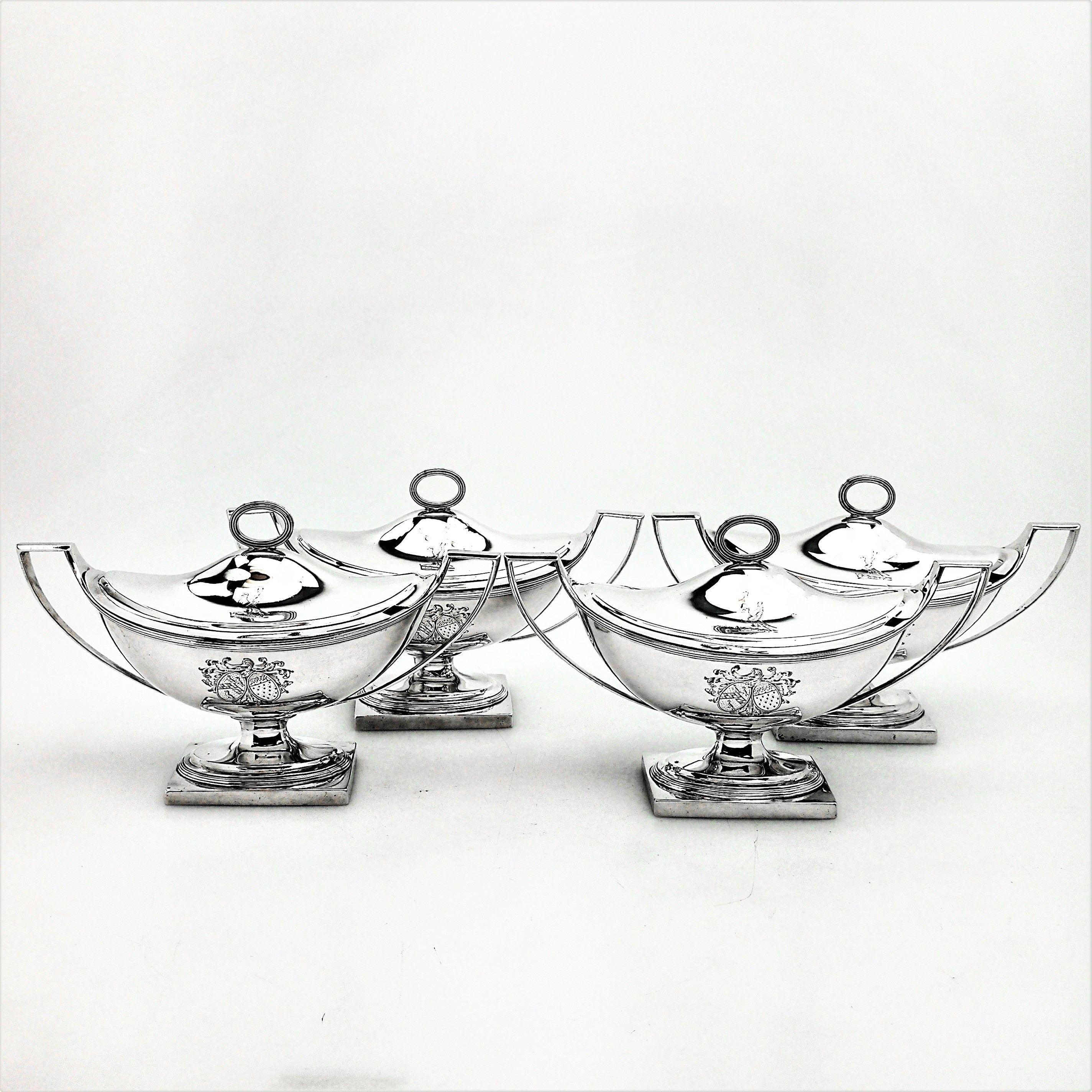 A set of four antique George III Solid Silver Sauce Tureens in a Classic oval form and standing on a square base. Each Tureen has a pair of impressive handles and the fitted domed lids have a reeded oval finial. Each tureen has a large engraved