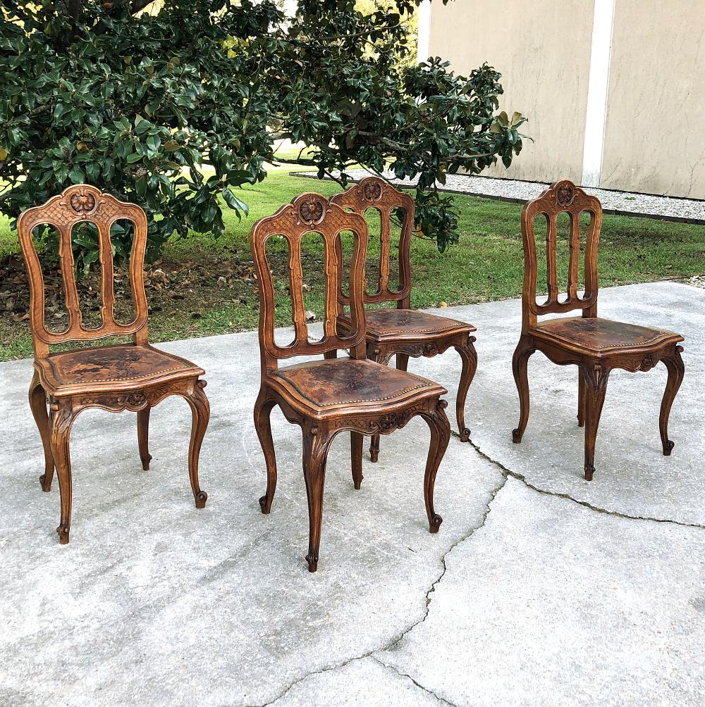 Set of 4 antique liegoise chairs with embossed leather seats are perfect for the breakfast room, game room, or for use as occasional chairs anywhere in the home or office! Sculpted from sturdy, solid oak, each features an arched seatback crown