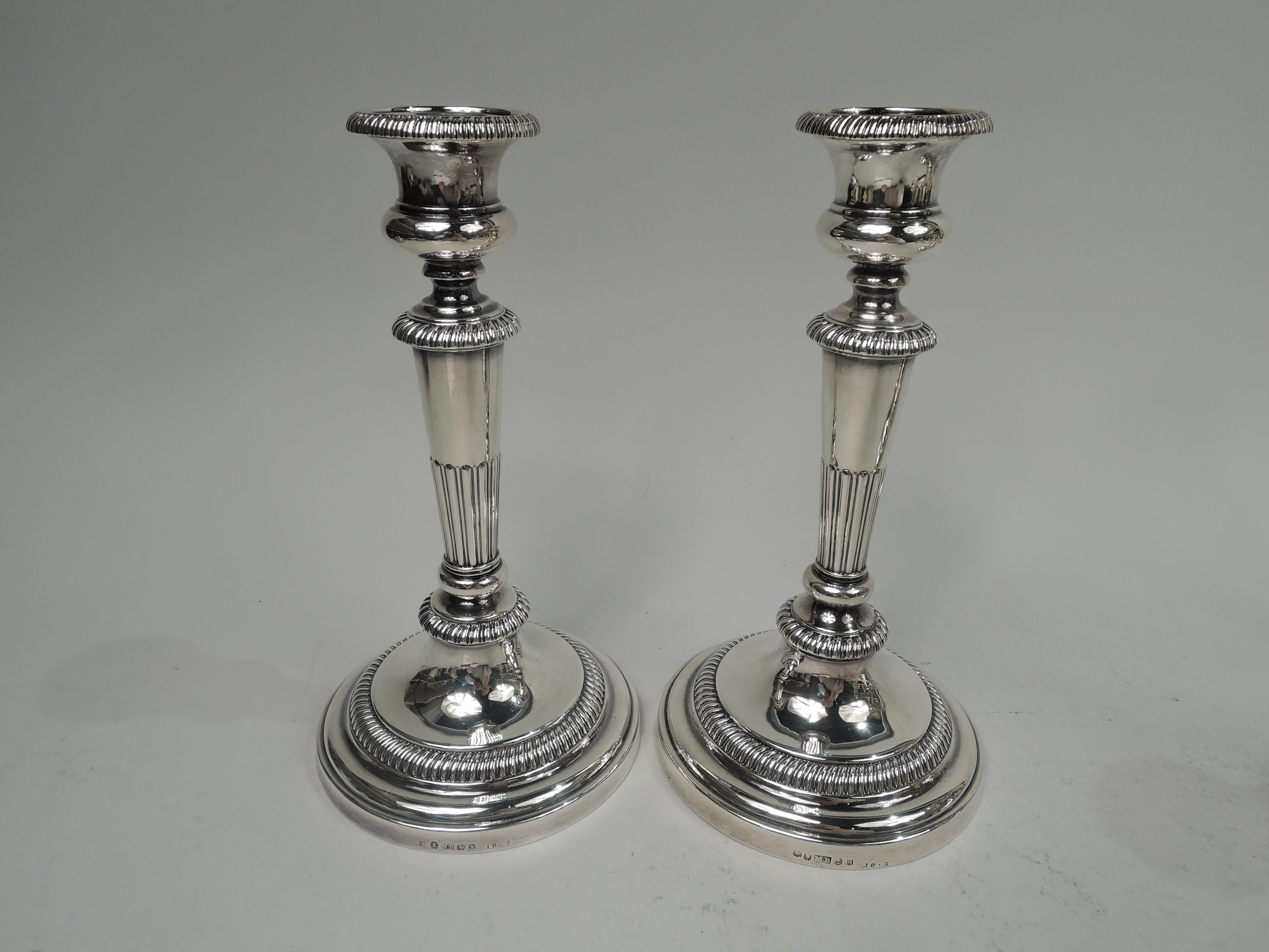 Set of 4 George III sterling silver candlesticks. Made by Matthew Boulton in Birmingham in 1814. Each: Bellied sconce on tapering half-gadrooned shaft with base knop and flange; domed foot. Gadrooning. Georgian Neoclassicism for traditional and