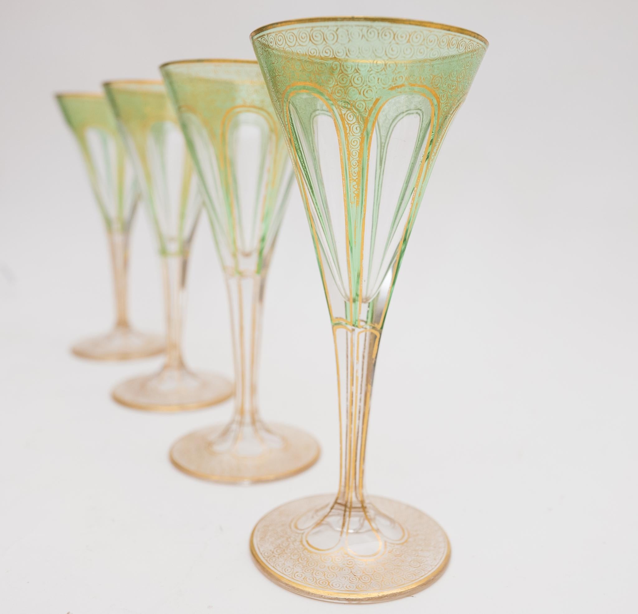 An elegant set of 4 antique last quarter 19th century glasses by the re known firm of Moser. This set has nice elongated cabochon style panels accented all over with 24 karat gilding. Fully cut and gilded stem and ready for entertaining ! In very