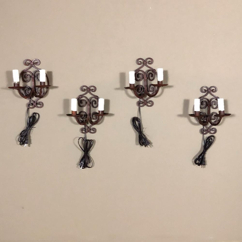 Set of 4 antique painted wrought iron electrified wall sconces are ideal for adding a rustic charm to any room, stairwell, hallway, bathroom ~ you name it,
circa early to mid-1900s.
Each measures 10.5 H x 9 W x 5 D.