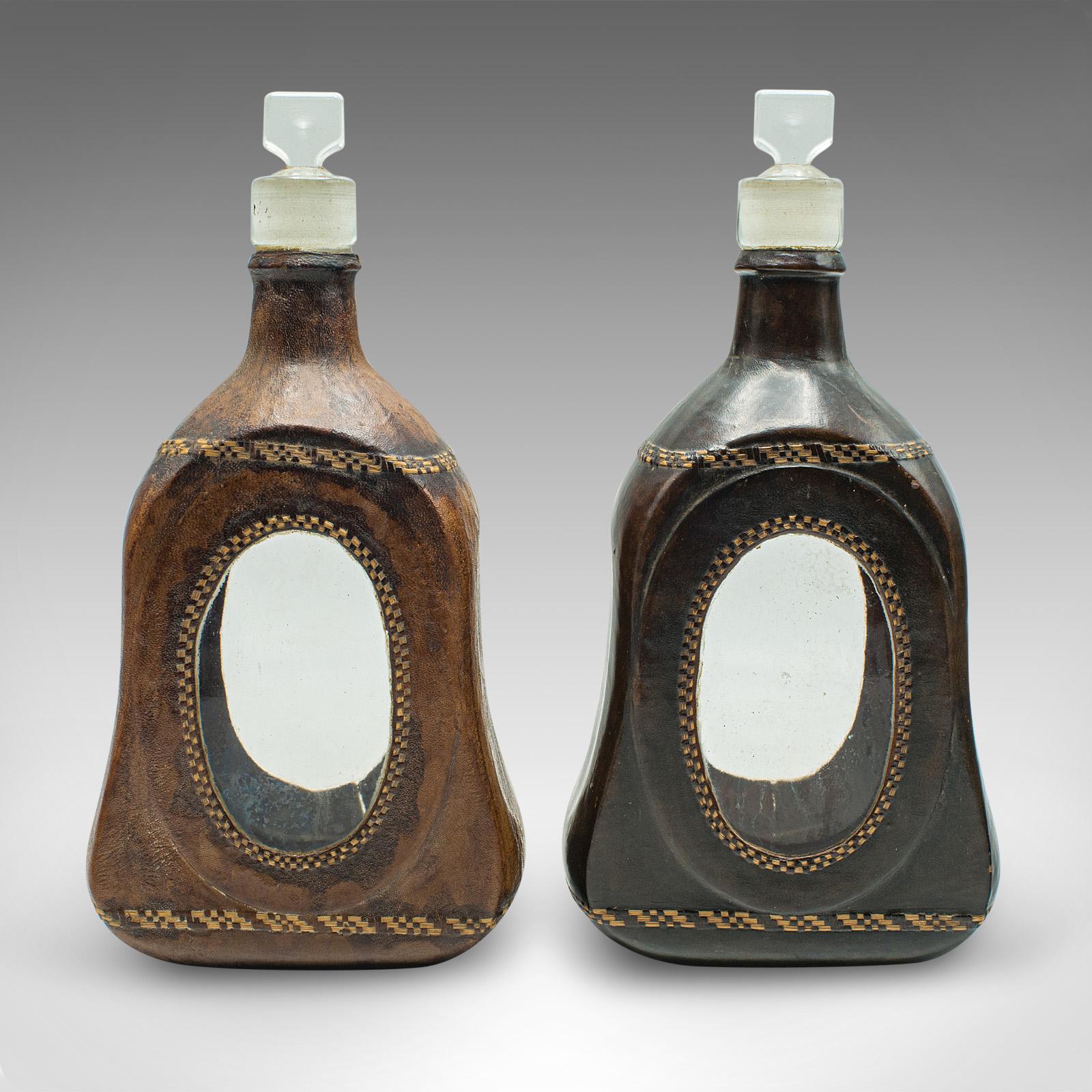 
This is a set of four antique spirit bottles. An English, leather dressed glass decanter, dating to the Victorian period and later, circa 1900.

Fascinating Victorian glassware, tastefully dressed in later Moroccan leather
Displaying a desirable