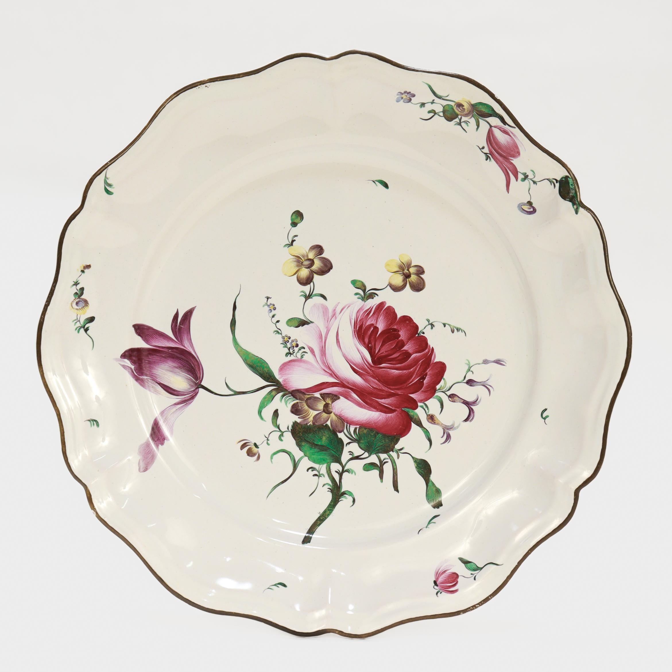 A fine set of 4 18th or 19th century French faience plates.

Attributed to the Hannong / Strasbourg-Haguenau factory in Strasbourg, France.

Each plate with a scalloped rim and painted floral decoration to the center.

Marked to the base of each