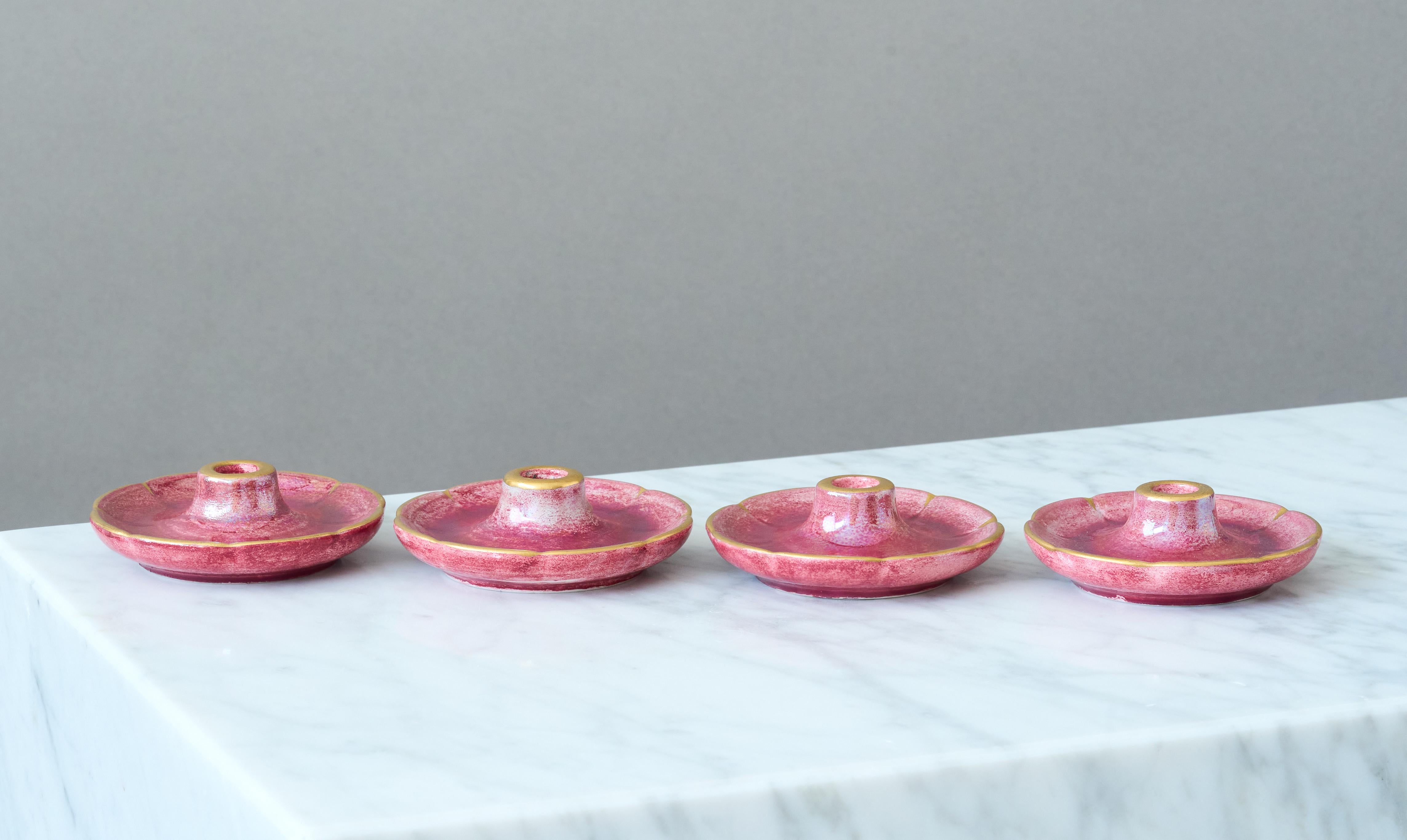 A set of 4 candlesticks with amazing pink lustre glaze and hand painted gold details. For narrow candles. Scandinavian Grace / Art Deco.
Made by Josef Ekberg at Gustavsberg, Sweden, 1930s.

Great condition, with some light wear to the gold. 
Signed